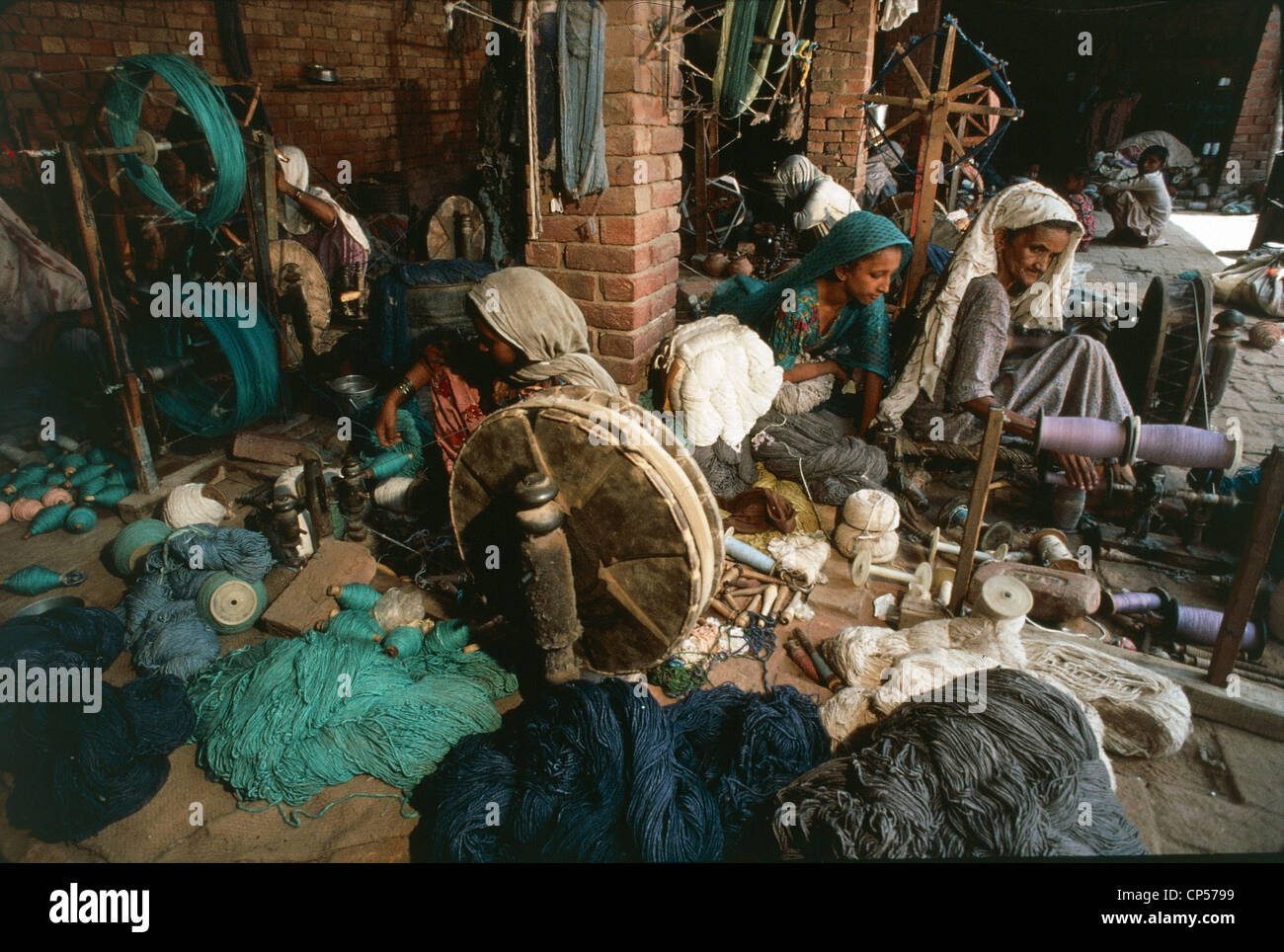 Pakistan - Il Punjab - donne occupate in tessuti artigianali con la ruota di filatura, vicino a Multan Foto Stock