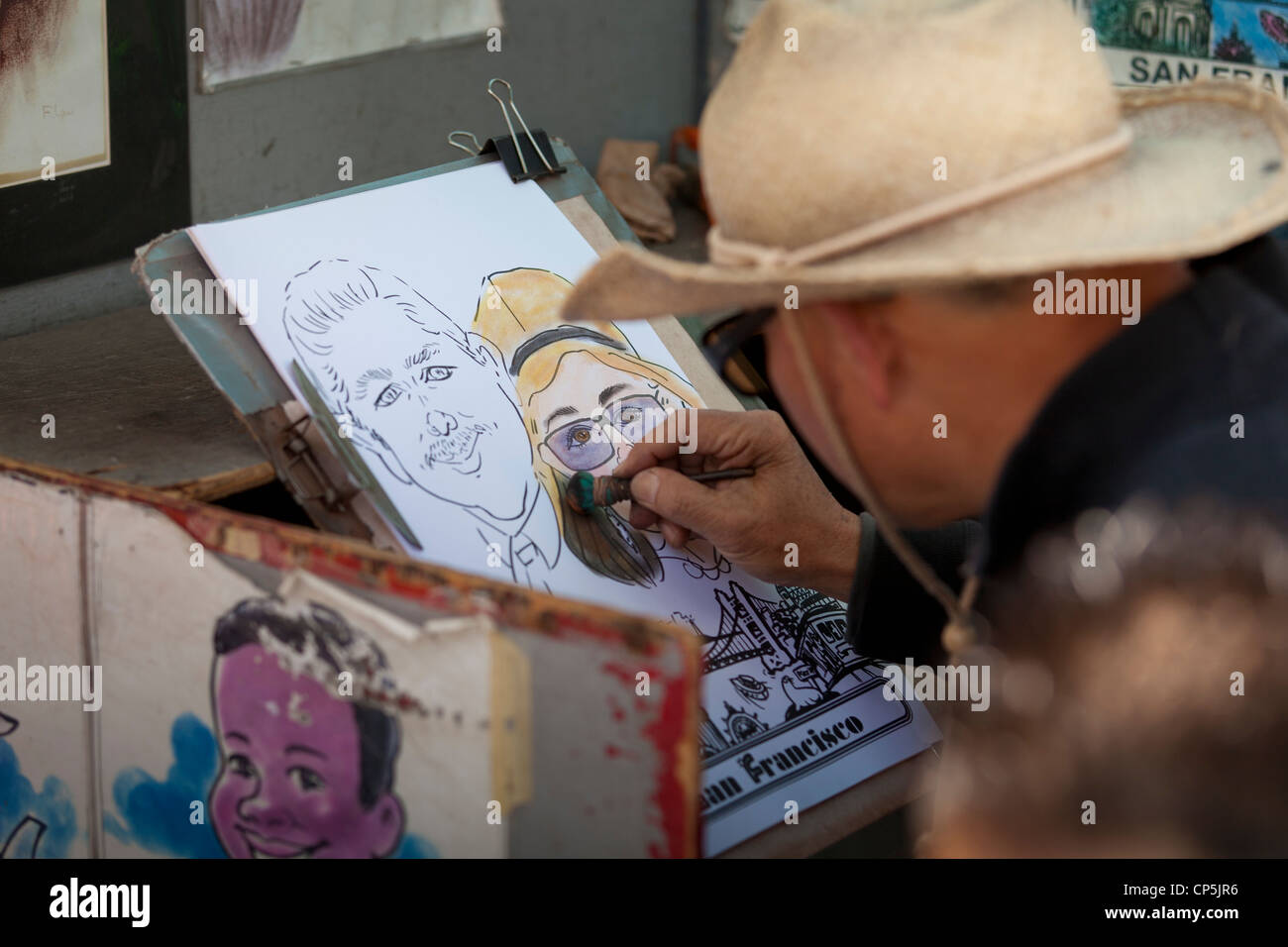 Street caricatura artista il disegno di un giovane ritratto - San Francisco, California USA Foto Stock