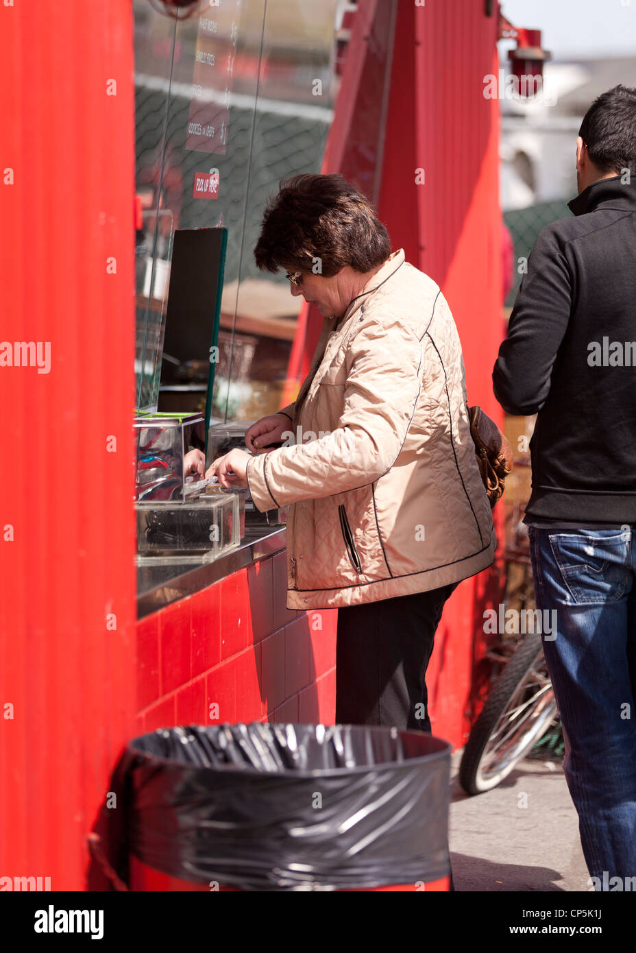 La donna a una finestra di biglietteria Foto Stock