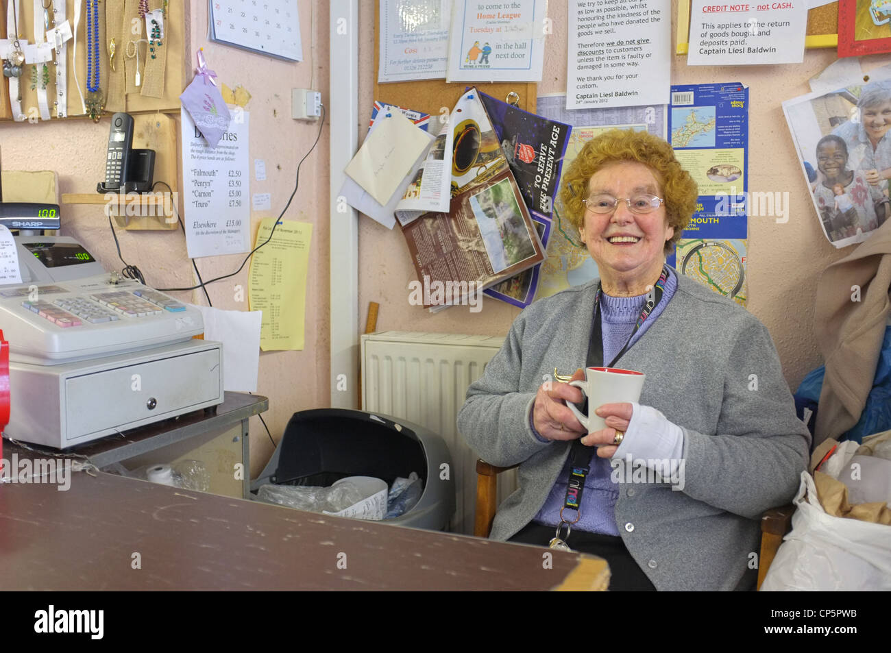 Un helper nell'Esercito della salvezza la carità shop in Falmouth, Cornwall Foto Stock