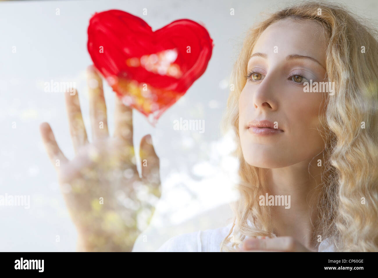 Donna tocca la foto di un cuore rosso Foto Stock