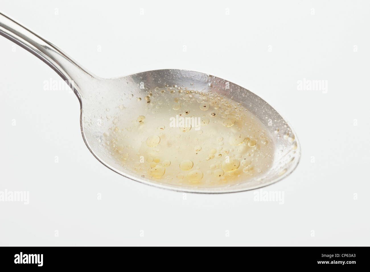 Zuppa di pollo in cucchiaio contro uno sfondo bianco Foto Stock