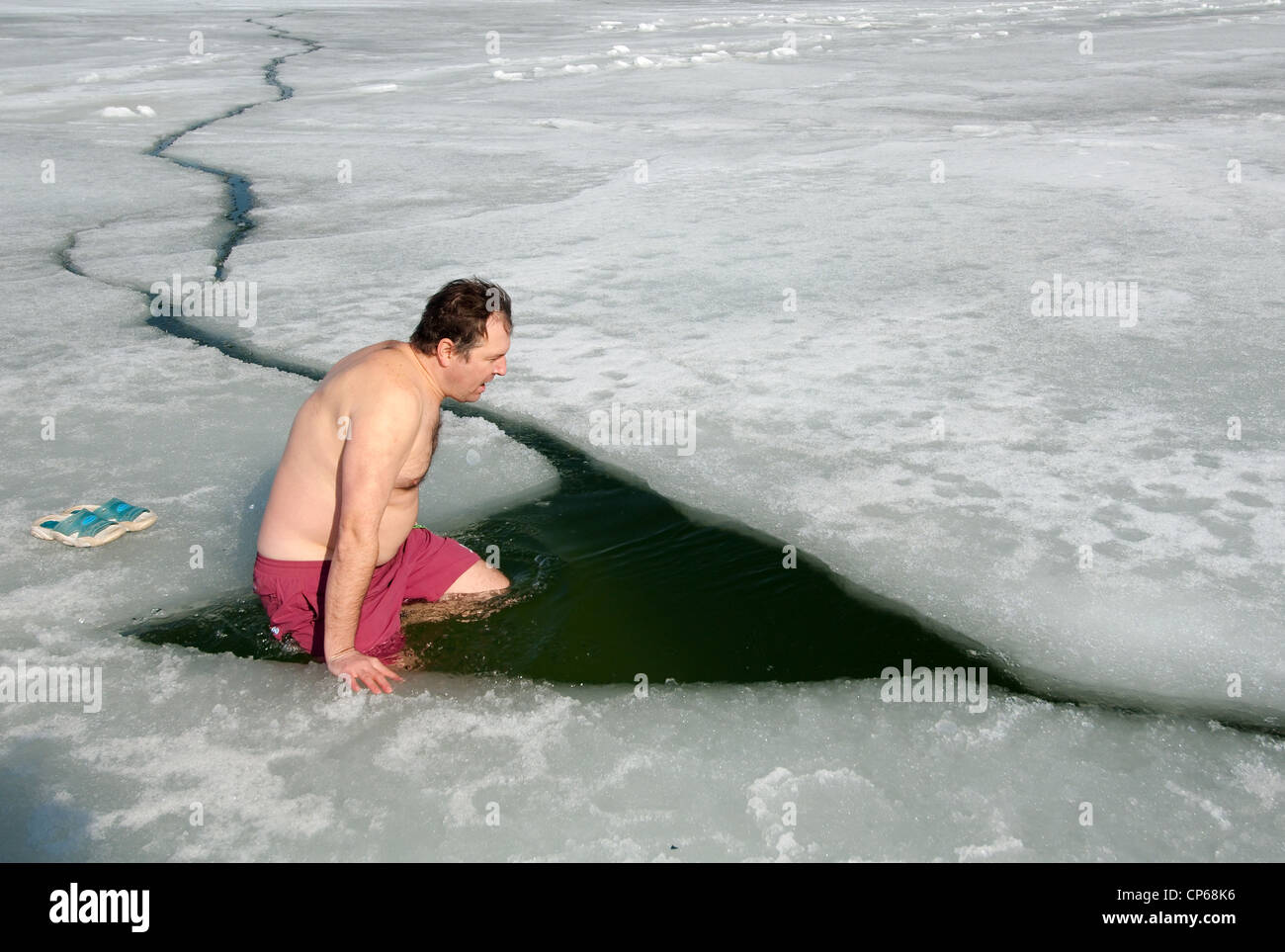 Uomo di nuoto nel foro di ghiaccio, Odessa, Ucraina, Europa orientale, Europa Foto Stock