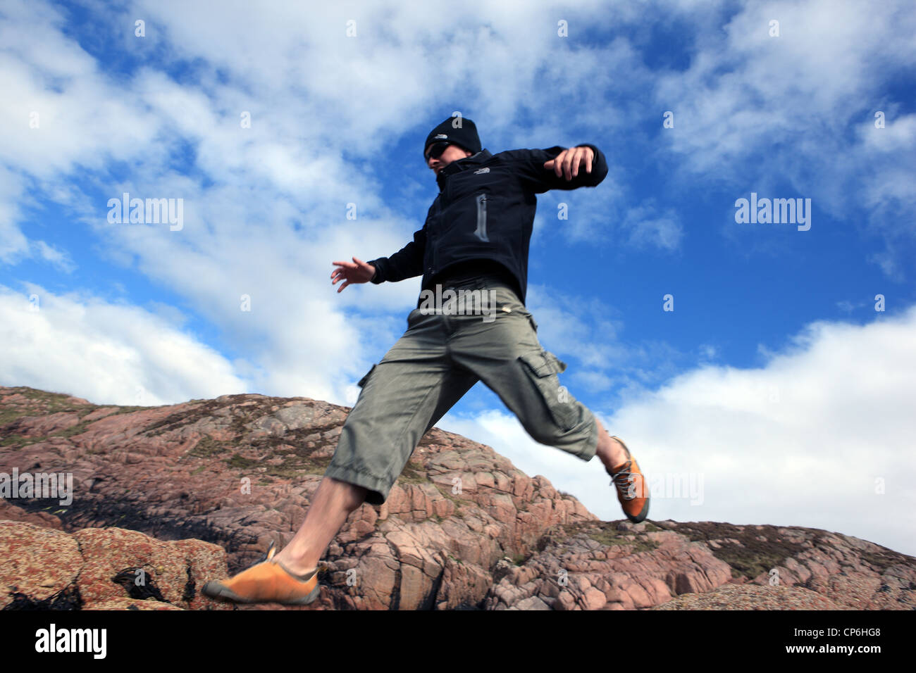 L'uomo jumping Rocks off Foto Stock
