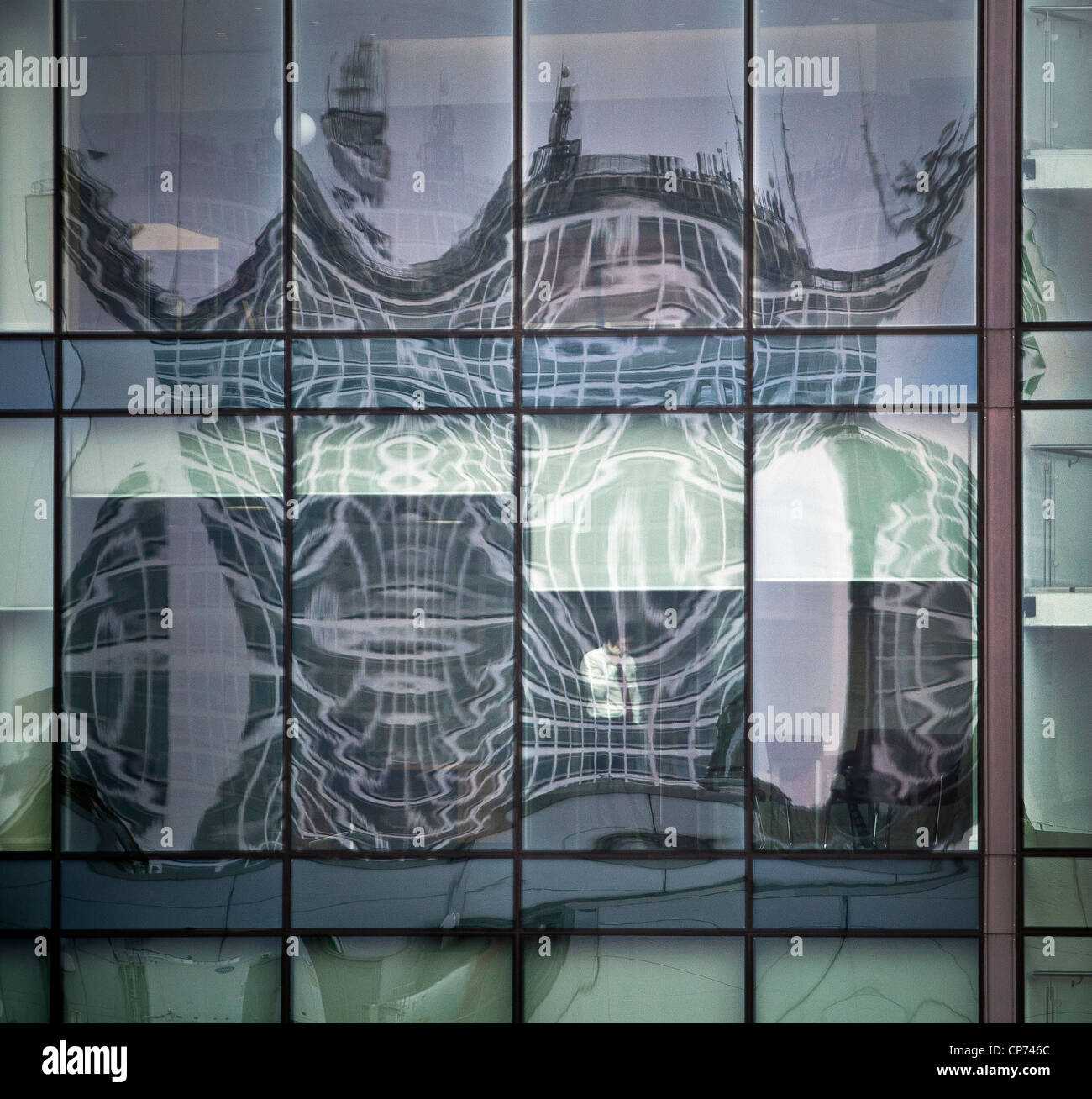 Una riflessione in un centro finestra di ufficio e un uomo su un telefono mobile. Foto Stock