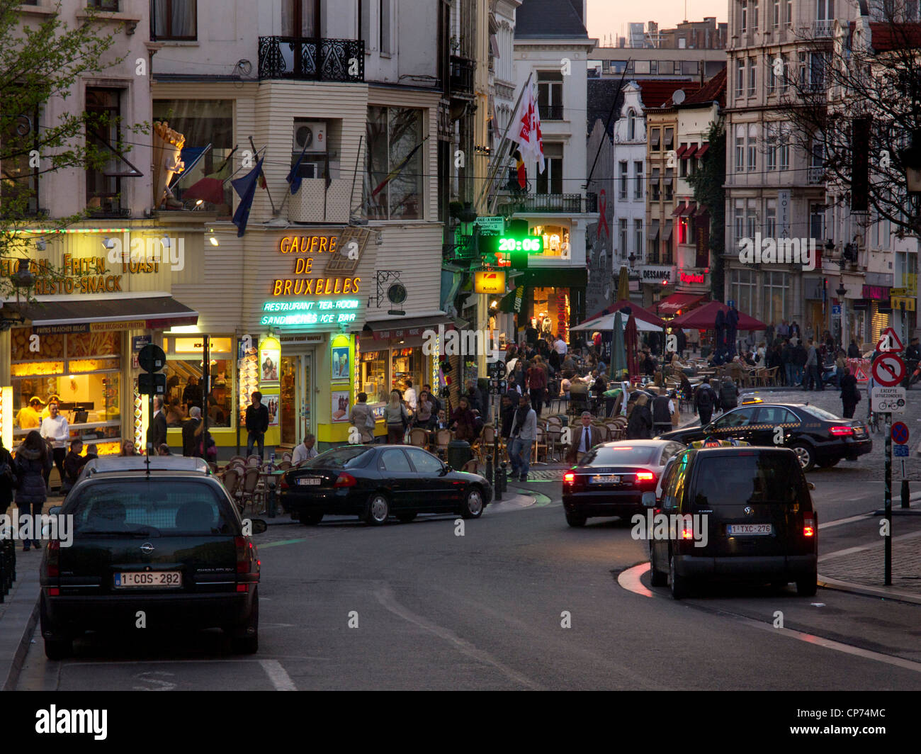 Tramonto nel centro di Bruxelles con molte persone, snackbars, e pochi taxi. Foto Stock