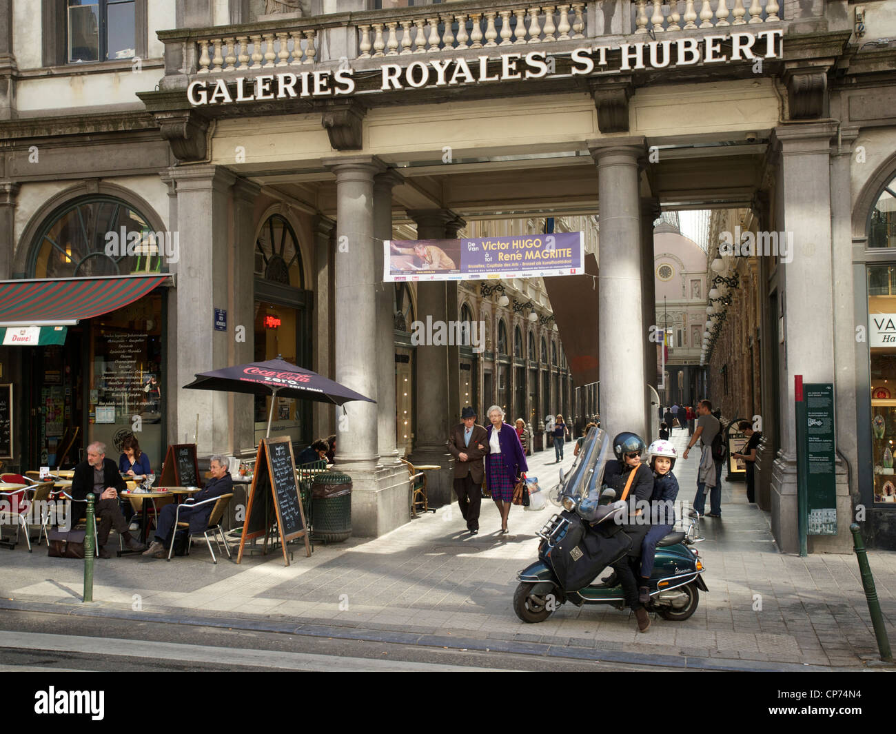 Galeries Royales Saint Hubert, Bruxelles, Belgio, con il vecchio paio di shopping, e la madre e il bambino su scooter. Foto Stock