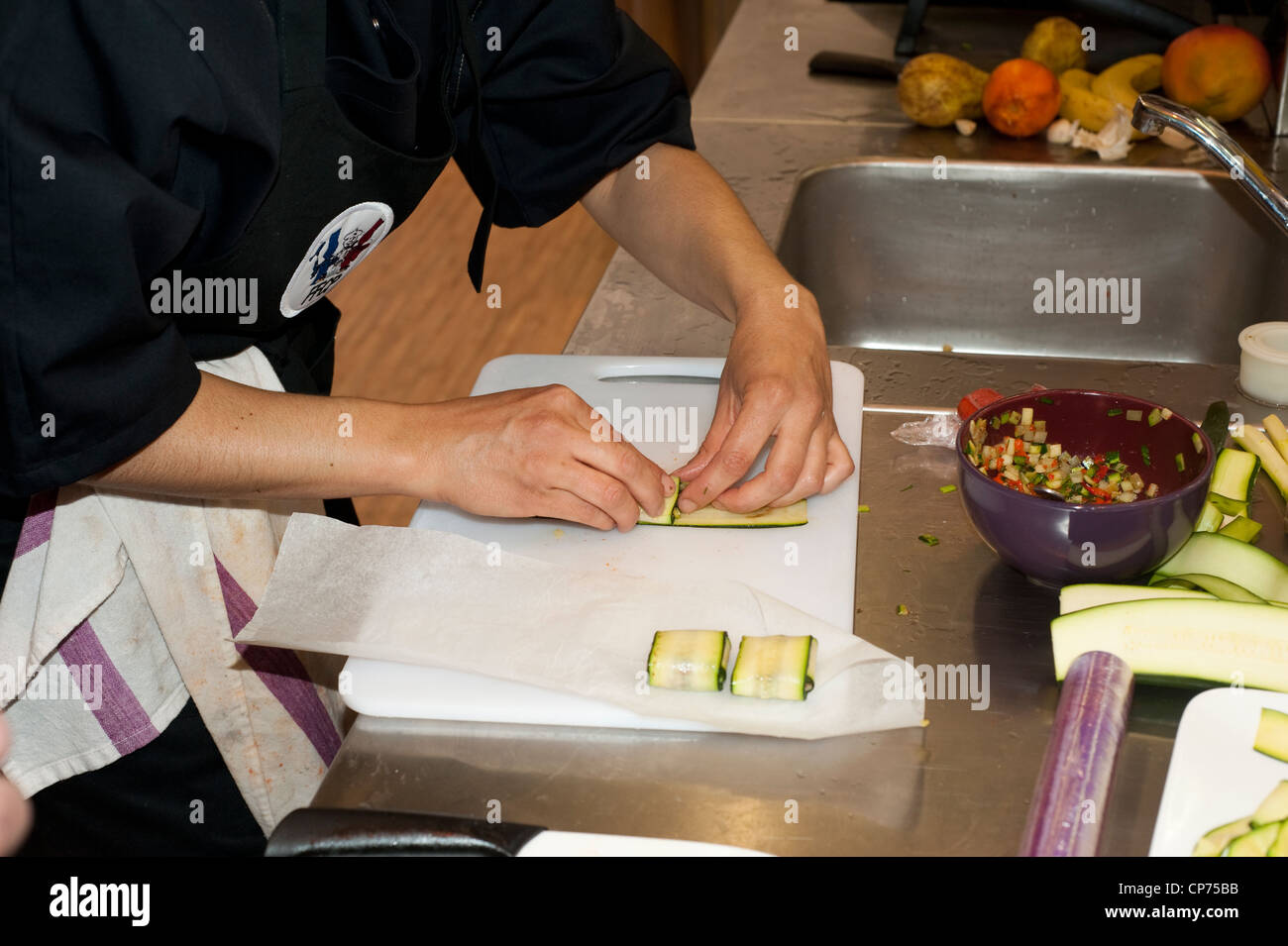 Parigi, Francia - Donna styling fette di zucchine durante la cottura la concorrenza Foto Stock