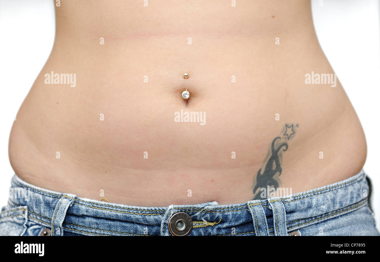 22 year old femmina con belly button bar e tatuaggio Foto Stock