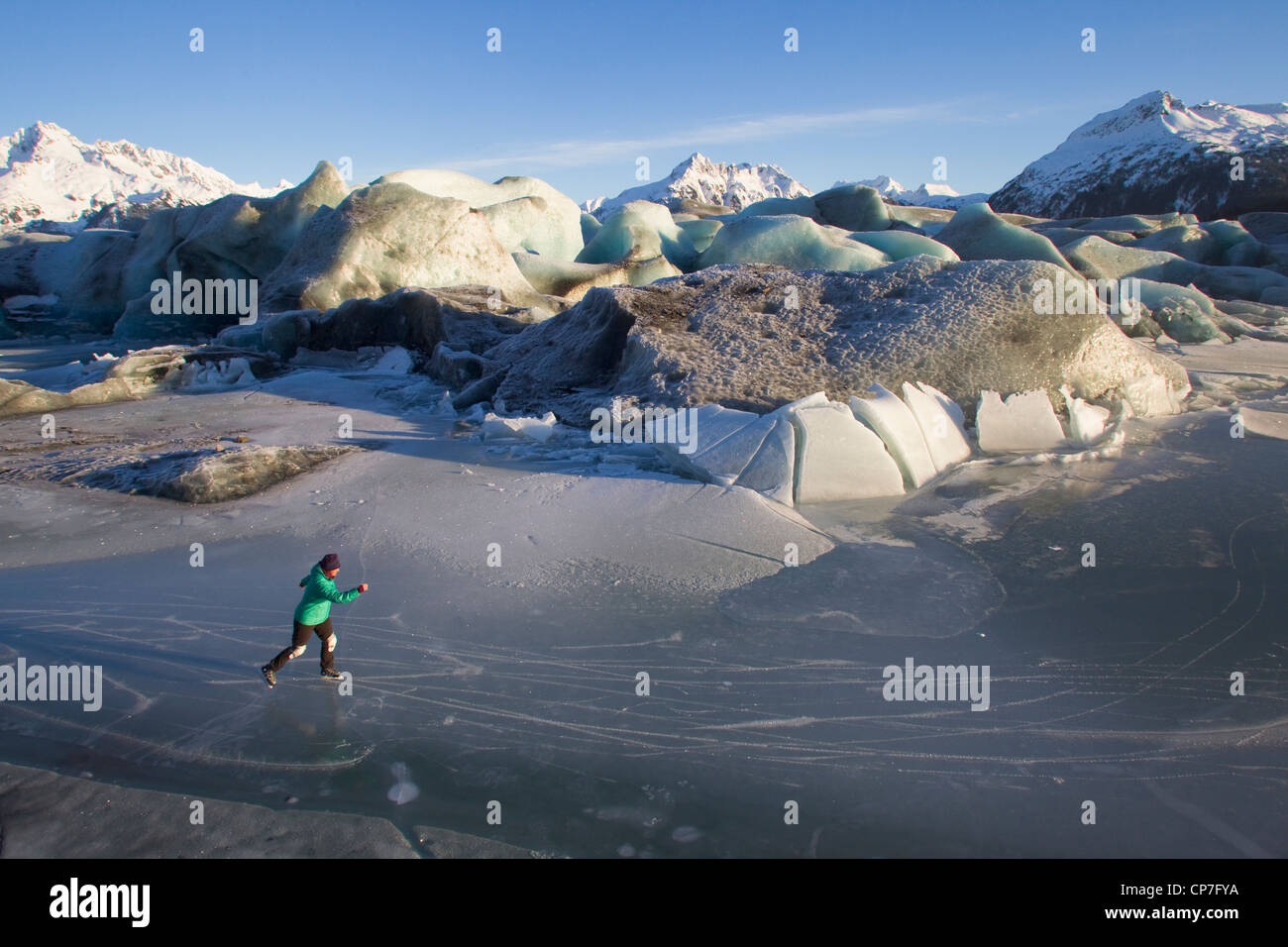Donna pattinaggio sul ghiaccio tra rotte iceberg di Sheridan ghiacciaio, Chugach Mountains vicino a Cordova, centromeridionale Alaska, molla Foto Stock