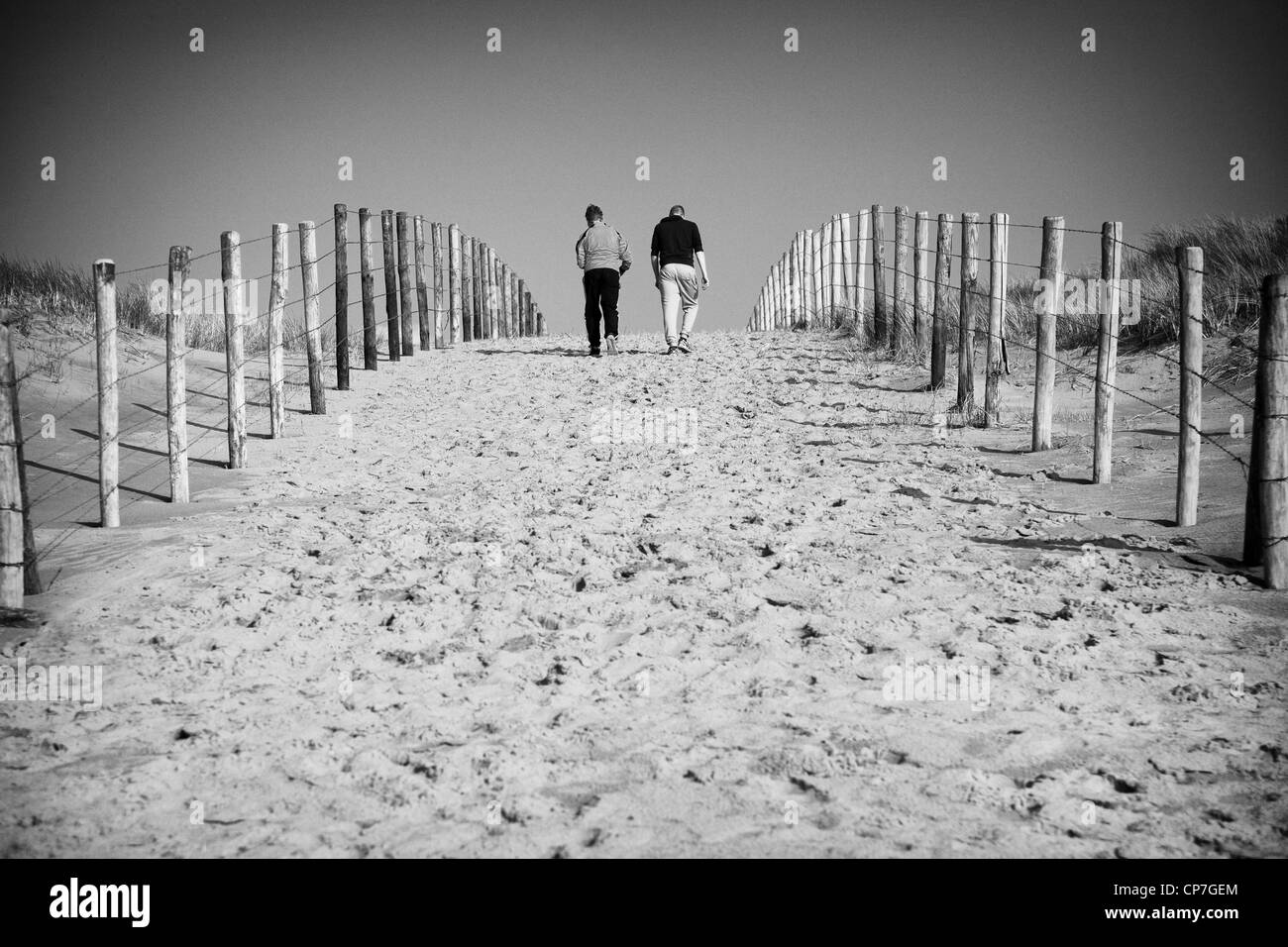 Due uomini in esecuzione in salita dal lato della spiaggia di Noordwijk Foto Stock