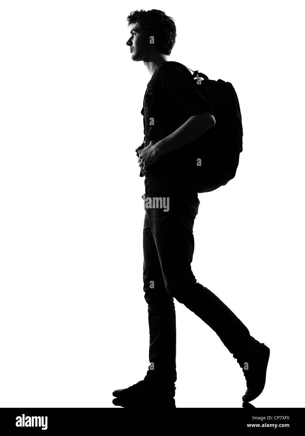 Giovane uomo backpacker silhouette a piedi in studio isolato su sfondo bianco Foto Stock