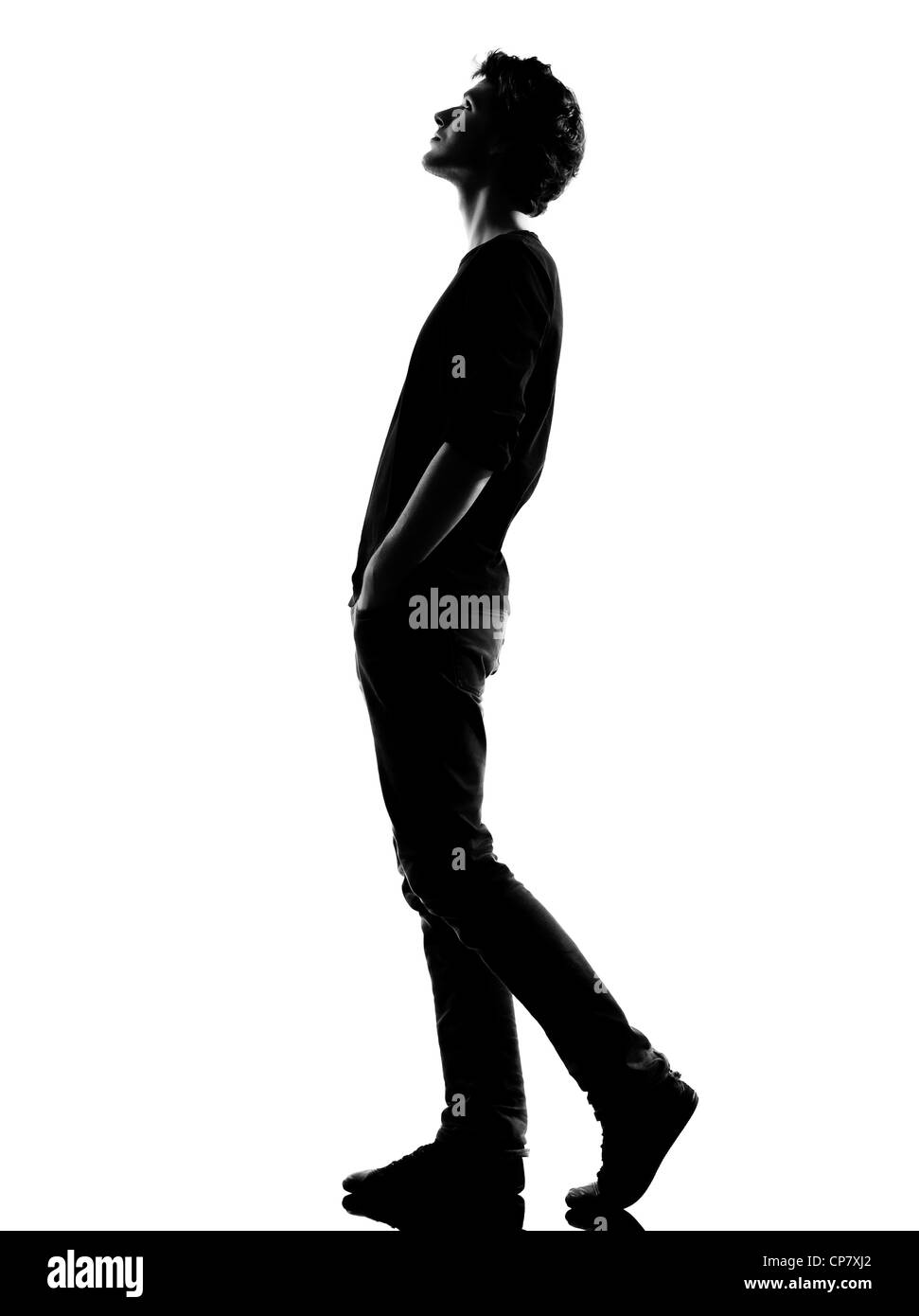 Giovane uomo che cammina cercando silhouette in studio isolato su sfondo  bianco Foto stock - Alamy