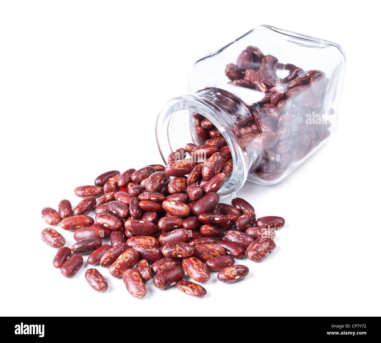 Rosso screziato fagioli kidney sparsi su uno sfondo bianco dal barattolo di vetro Foto Stock
