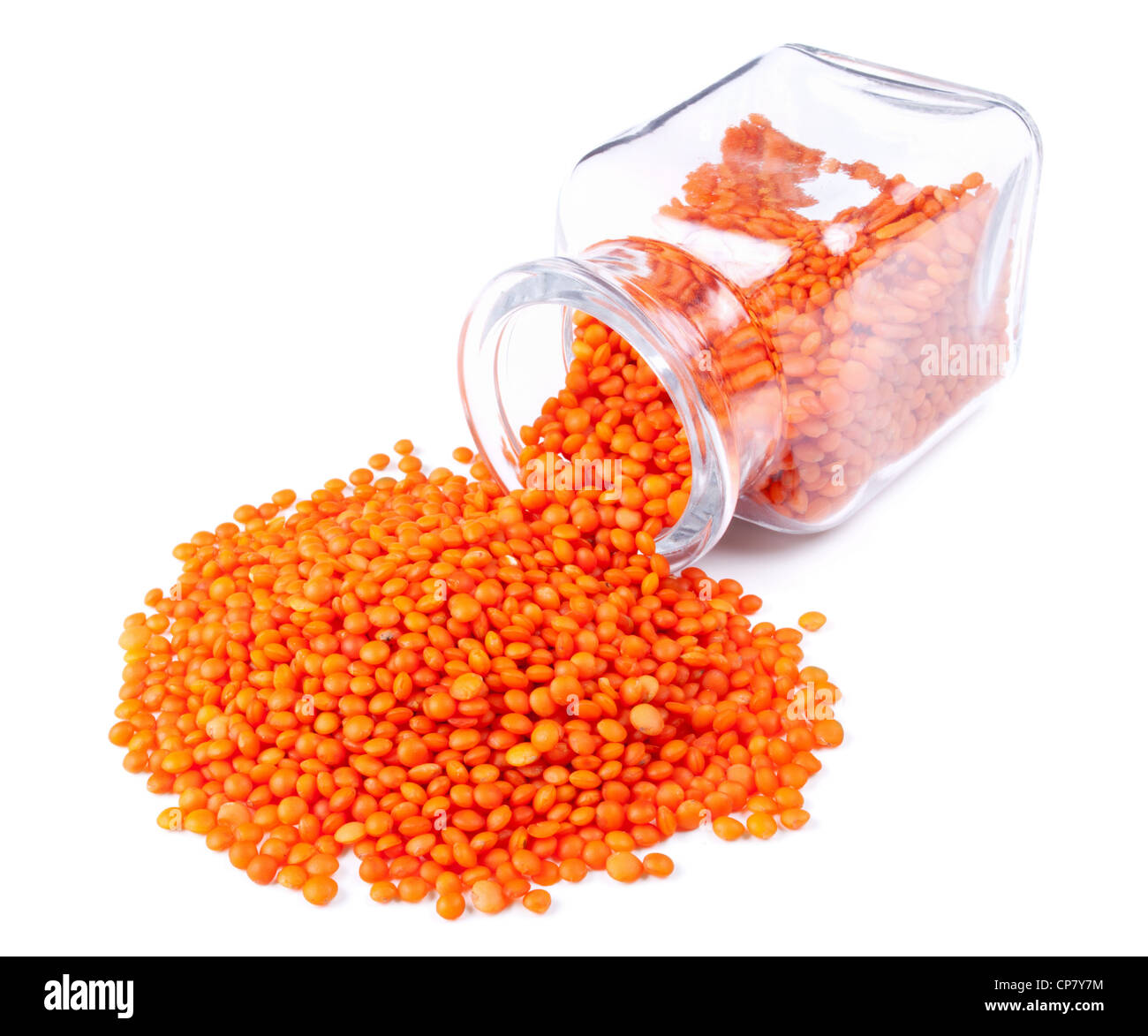Di lenticchie rosse sparse su uno sfondo bianco dal barattolo di vetro Foto Stock
