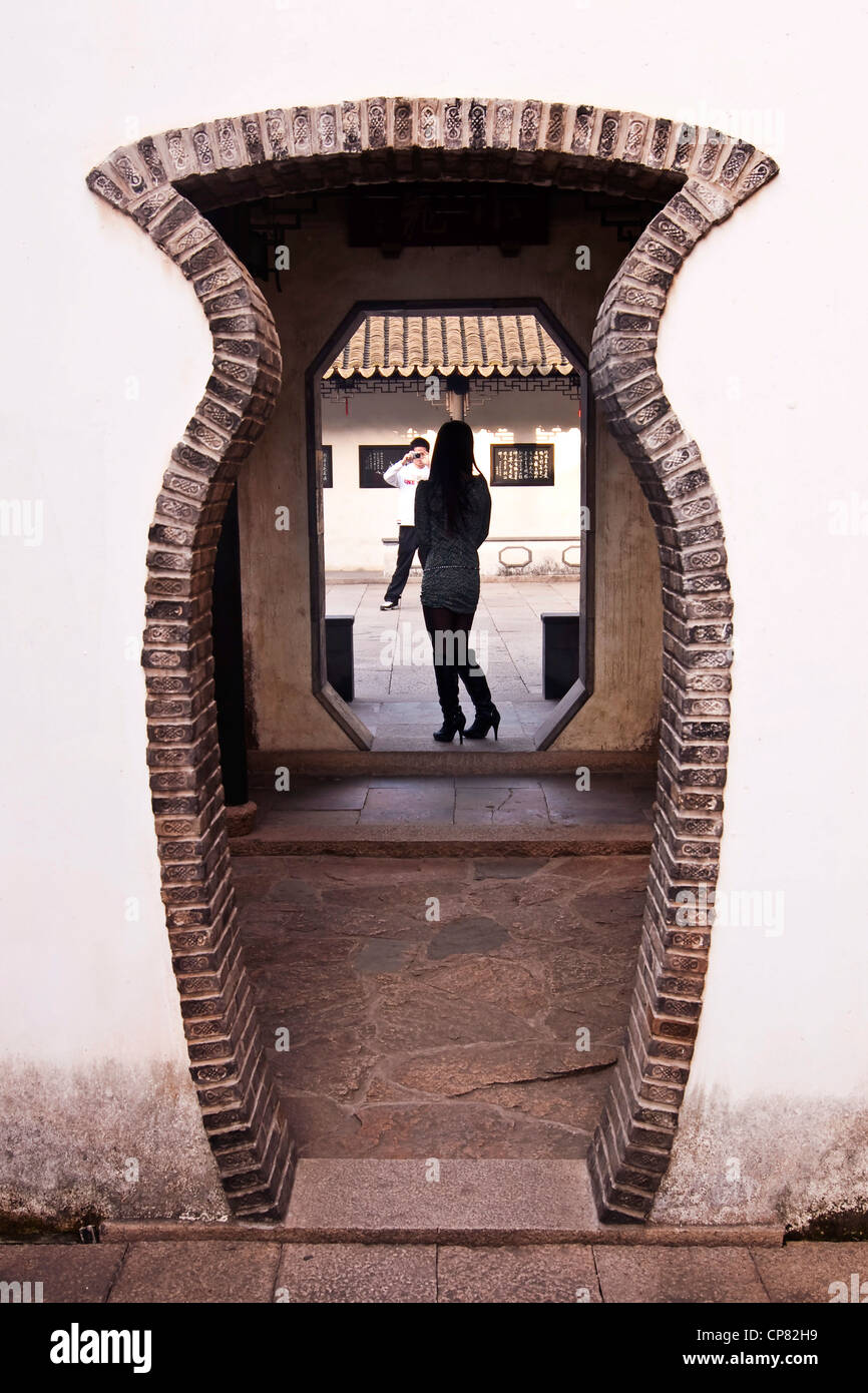 Giovane donna asiatica che posano per una foto nella parte anteriore del cinese tradizionale porta - Tongli vicino a Shanghai - Cina Foto Stock