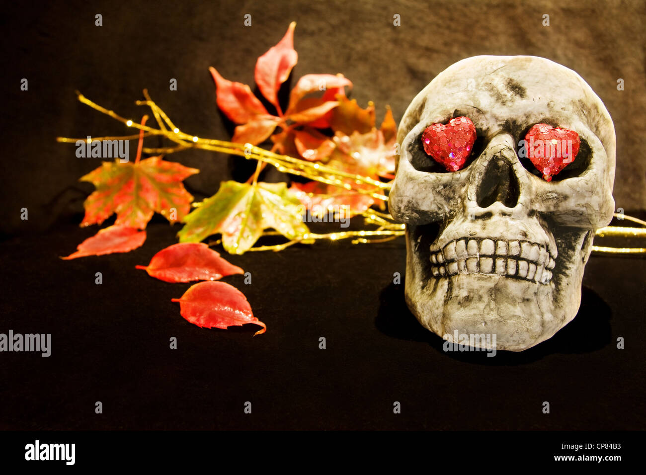 Celebrare la notte di Halloween con scary cranio e cuori rossi. Foto Stock