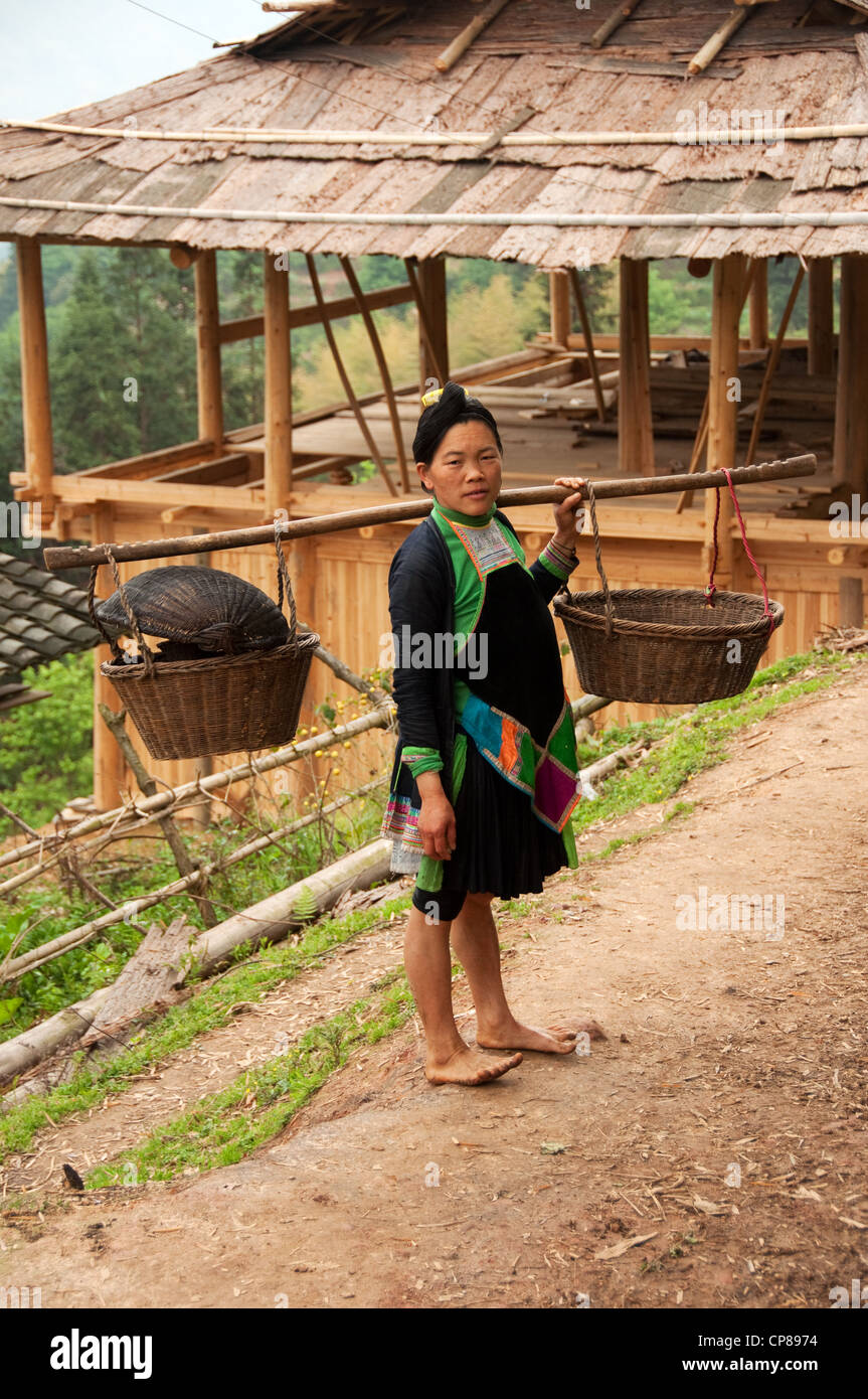 Un basha miao (pistola uomini) donna adulta che effettuano il trasporto di merci sulle sue spalle, Cina del Sud Foto Stock Un basha miao (pistola uomini) donna adulta che effettuano il trasporto di merci sulle sue spalle, Cina del Sud Foto Stock