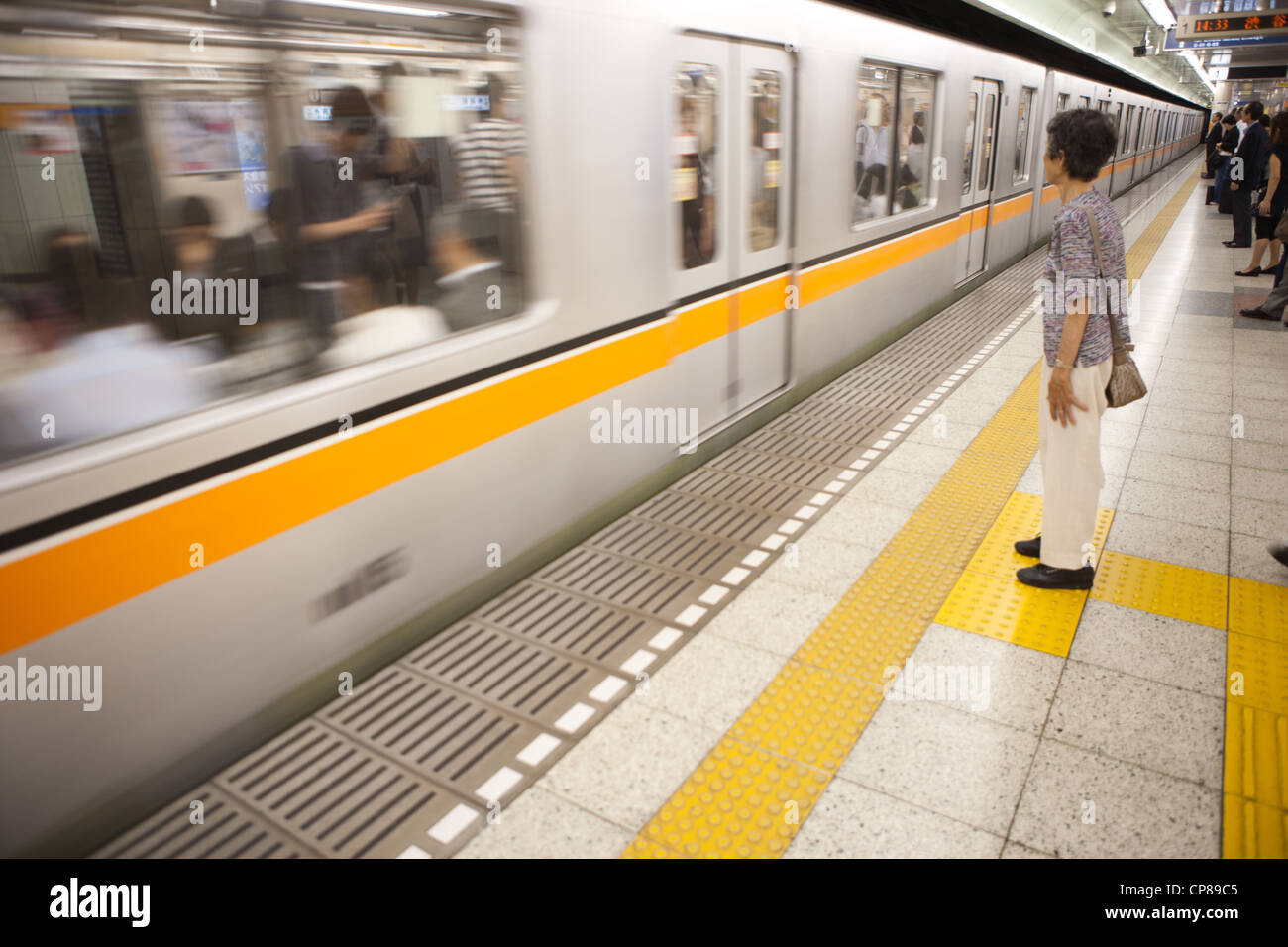 La donna in attesa di salire su un treno della metropolitana di Tokyo in Giappone. Foto Stock