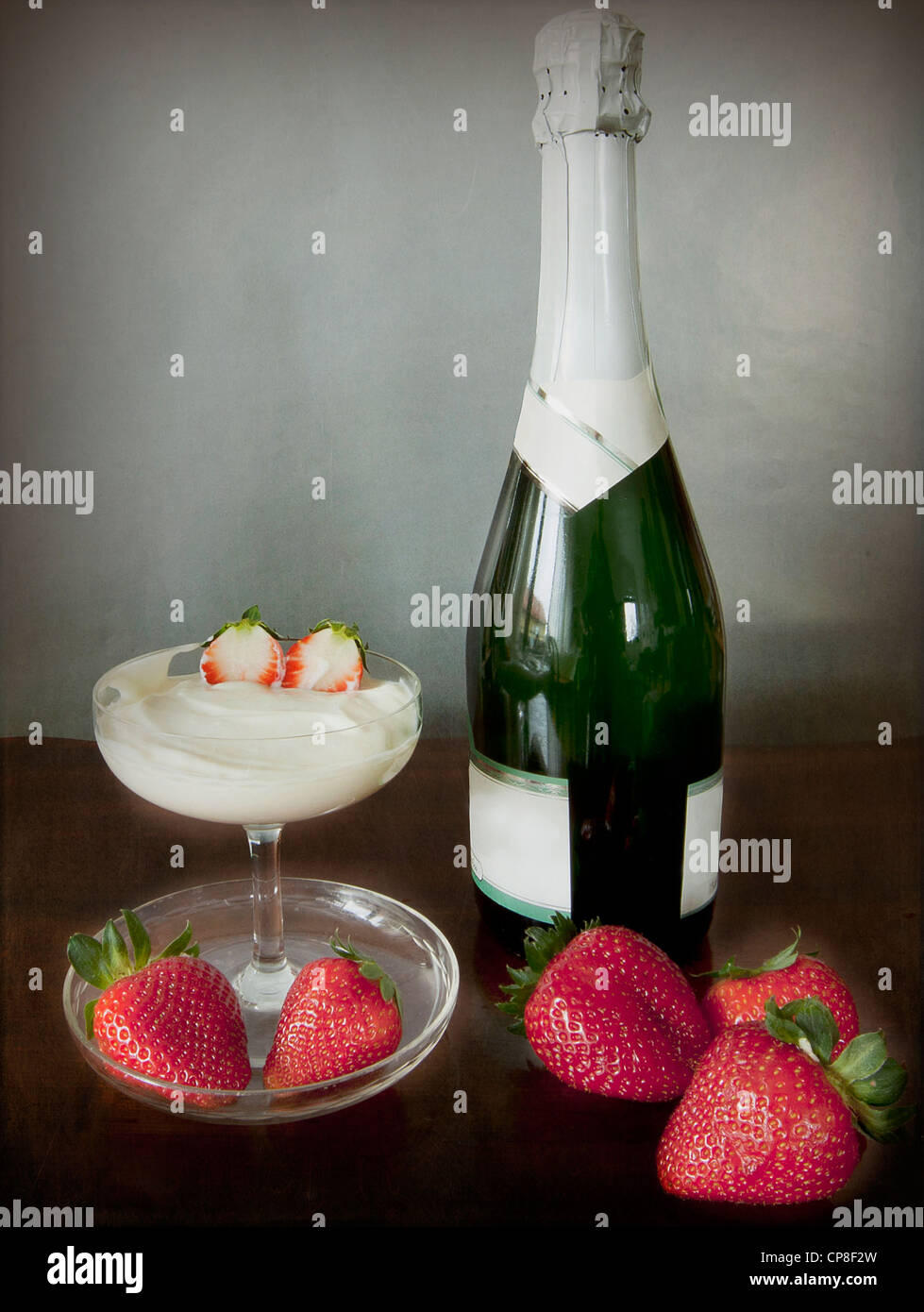Champagne, una tazza di panna fresca e fragole Foto Stock