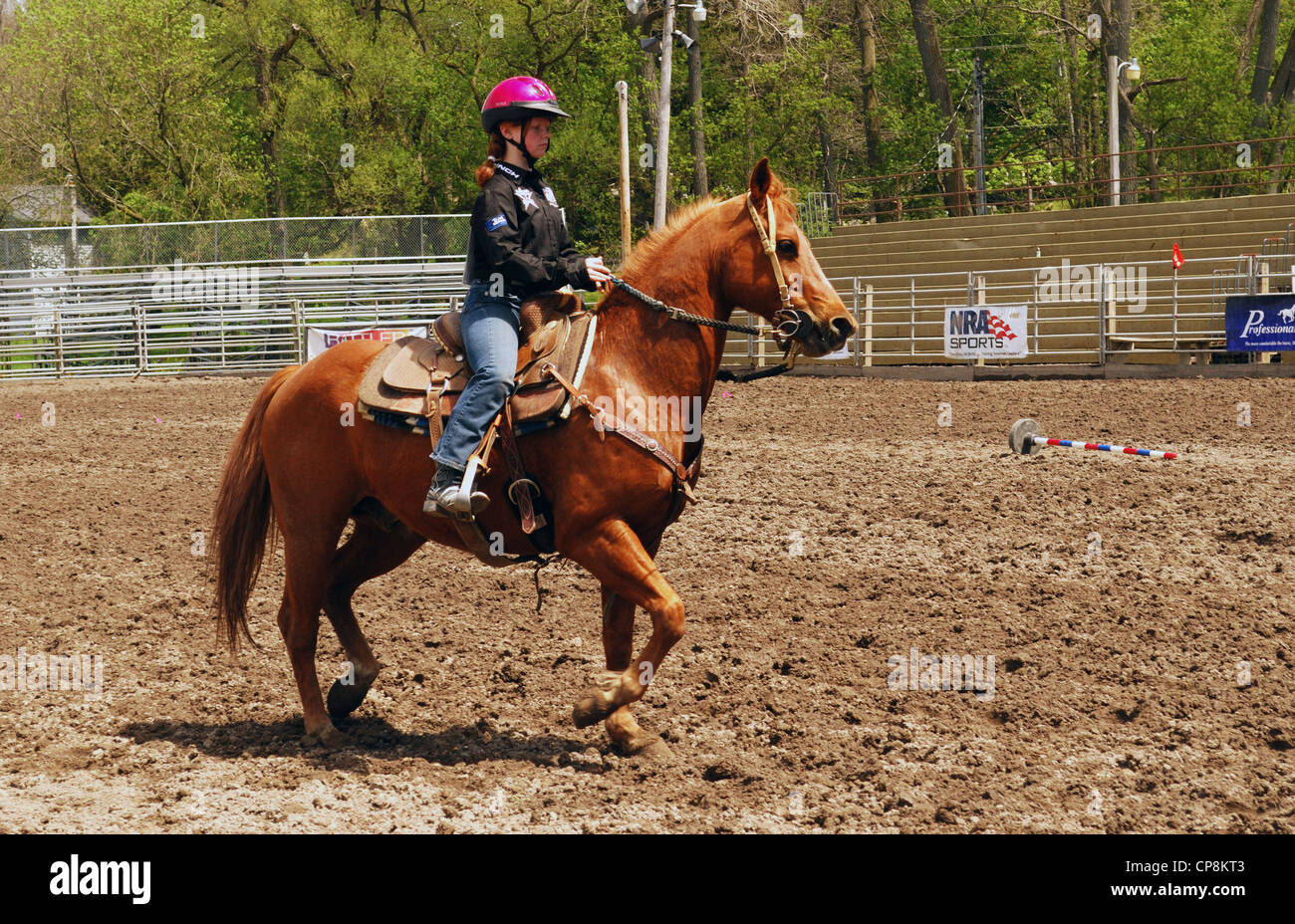 Teenage scuole alta ragazza raffredda il suo cavallo in Attica Rodeo. Foto Stock