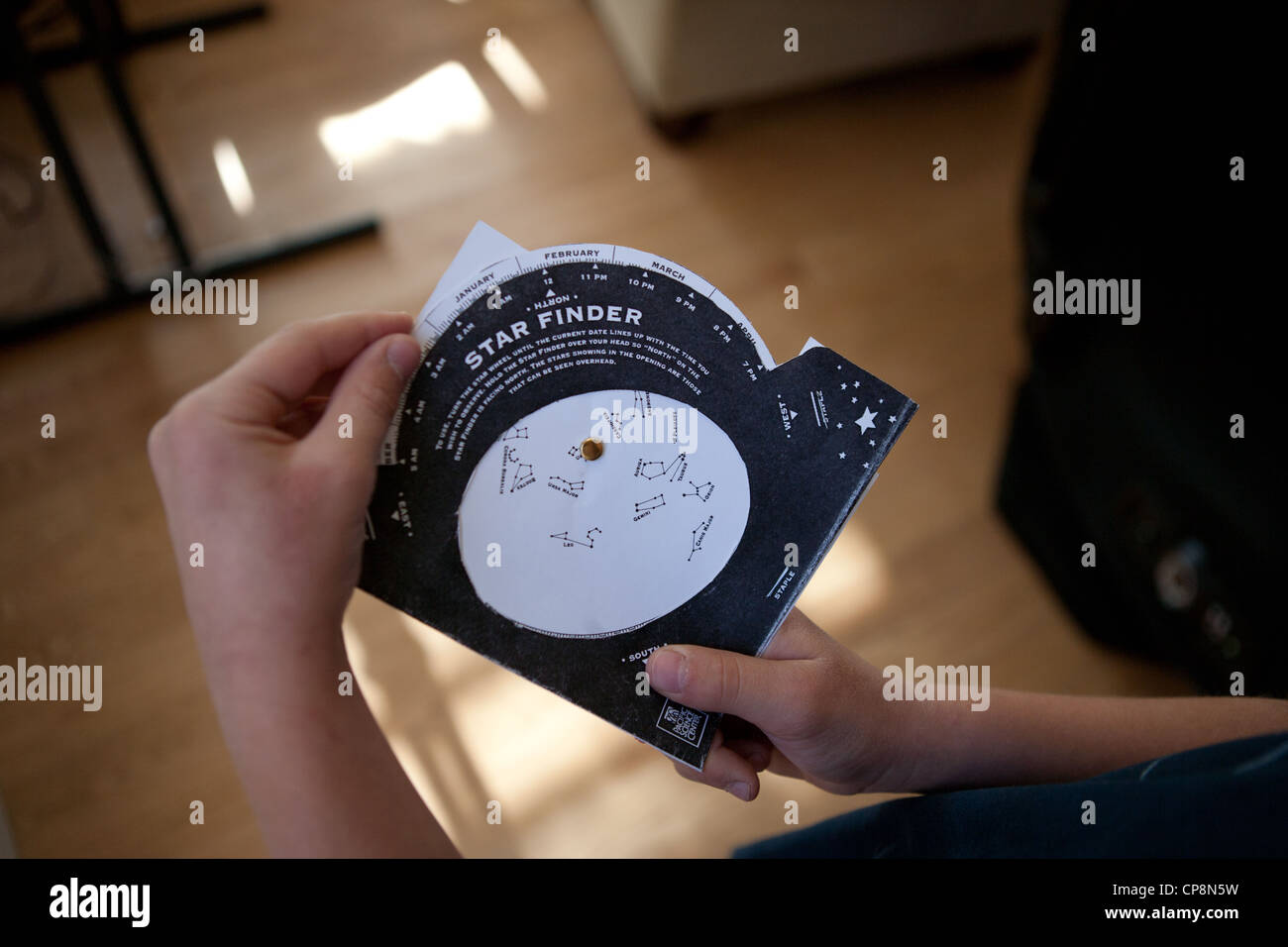 Un bambino tenendo la sua stella grafico del Finder per studiare la visuale del cielo stelle e costellazioni. Foto Stock