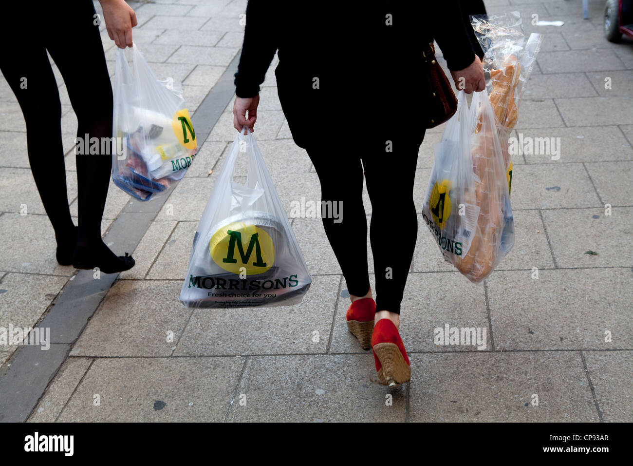Shopper con Morrisons sacchi da asporto Foto Stock