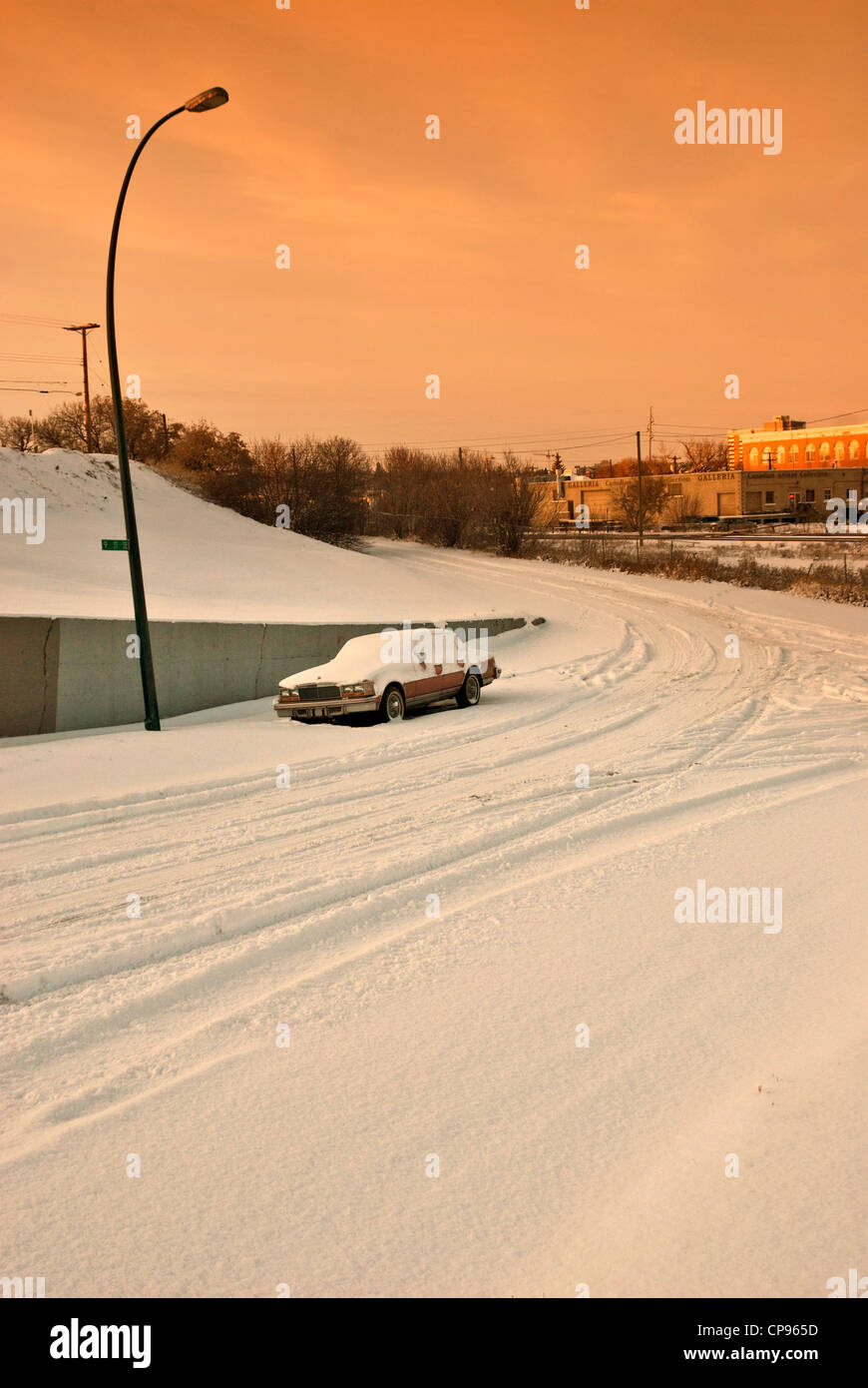 Un solitario auto parcheggiate congelati in un urbano inverno scape. Foto Stock