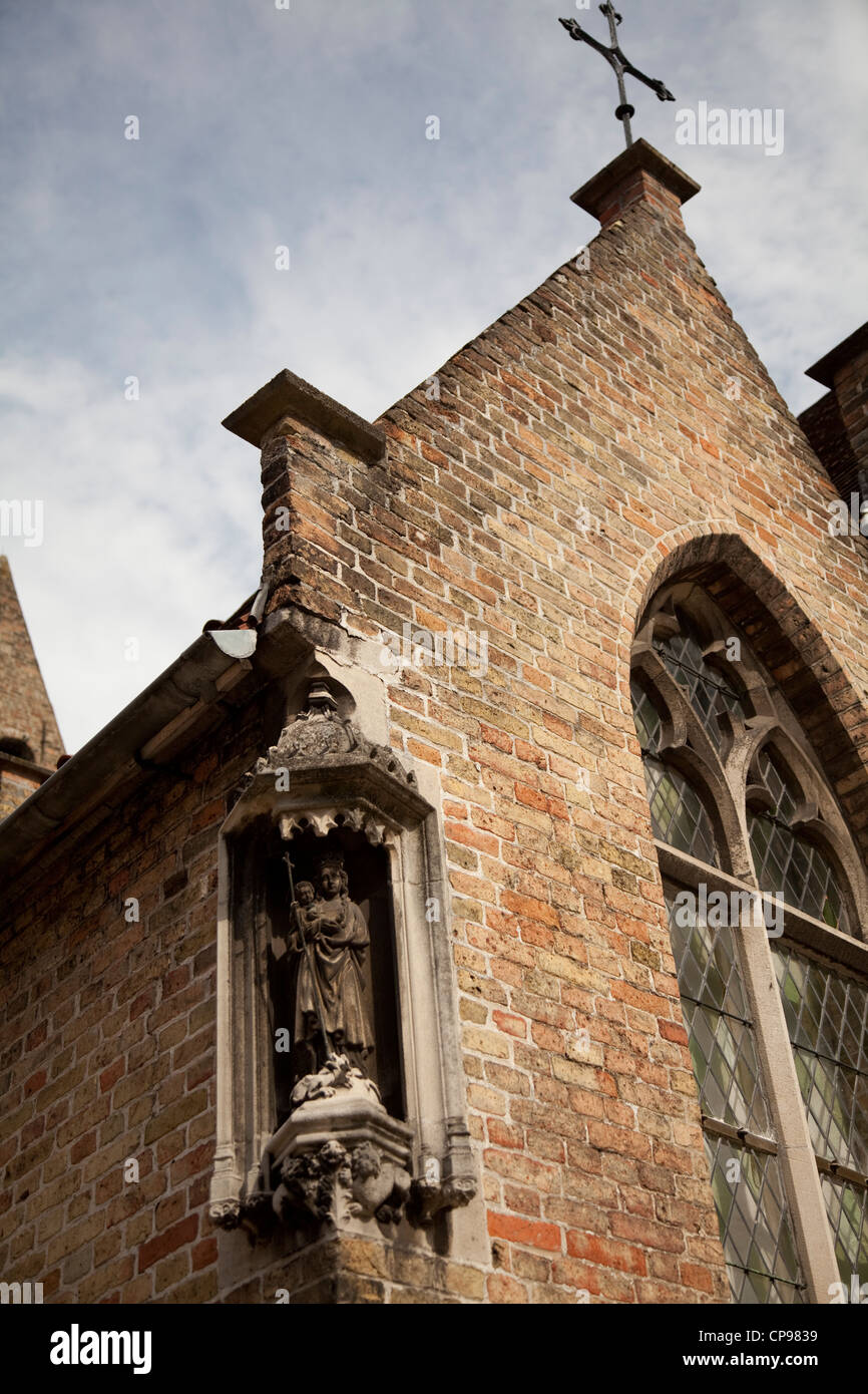 La sezione di Onze-Lieve-Vrouwekerk (la chiesa di Nostra Signora) con angolo statua barocca e la finestra di vetro Bruge Belgio Foto Stock