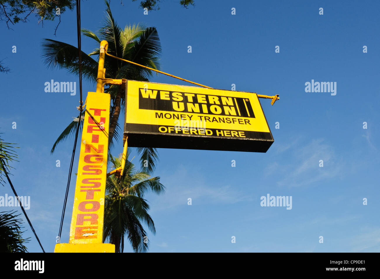 Segno posto di trasferimento di denaro di Western Union offerti qui, cielo blu, palme da cocco - Sabang Puerto Galera Filippine sud-est asiatico Foto Stock