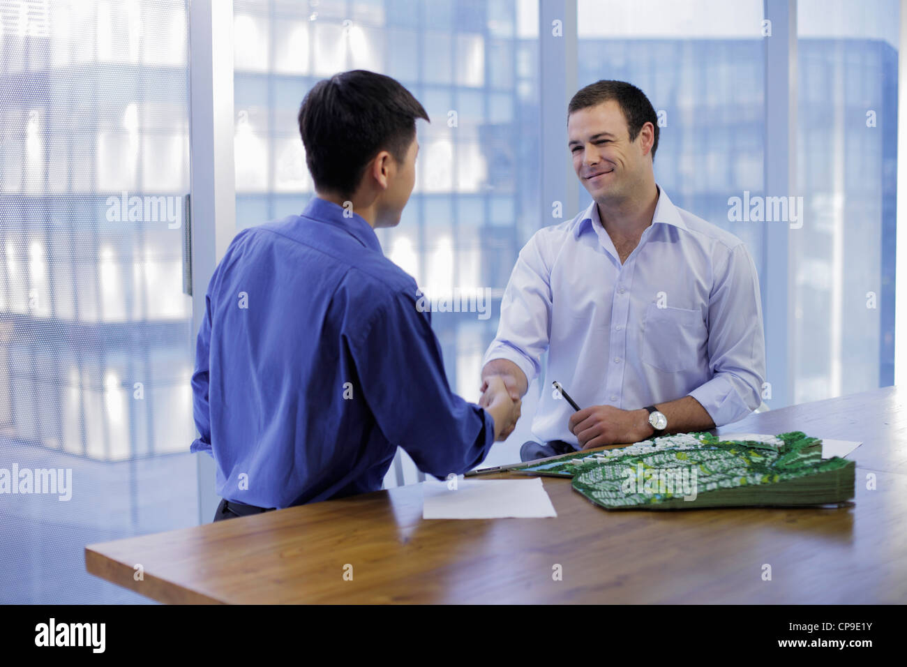 Giovani uomini stringono le mani in un ufficio moderno Foto Stock