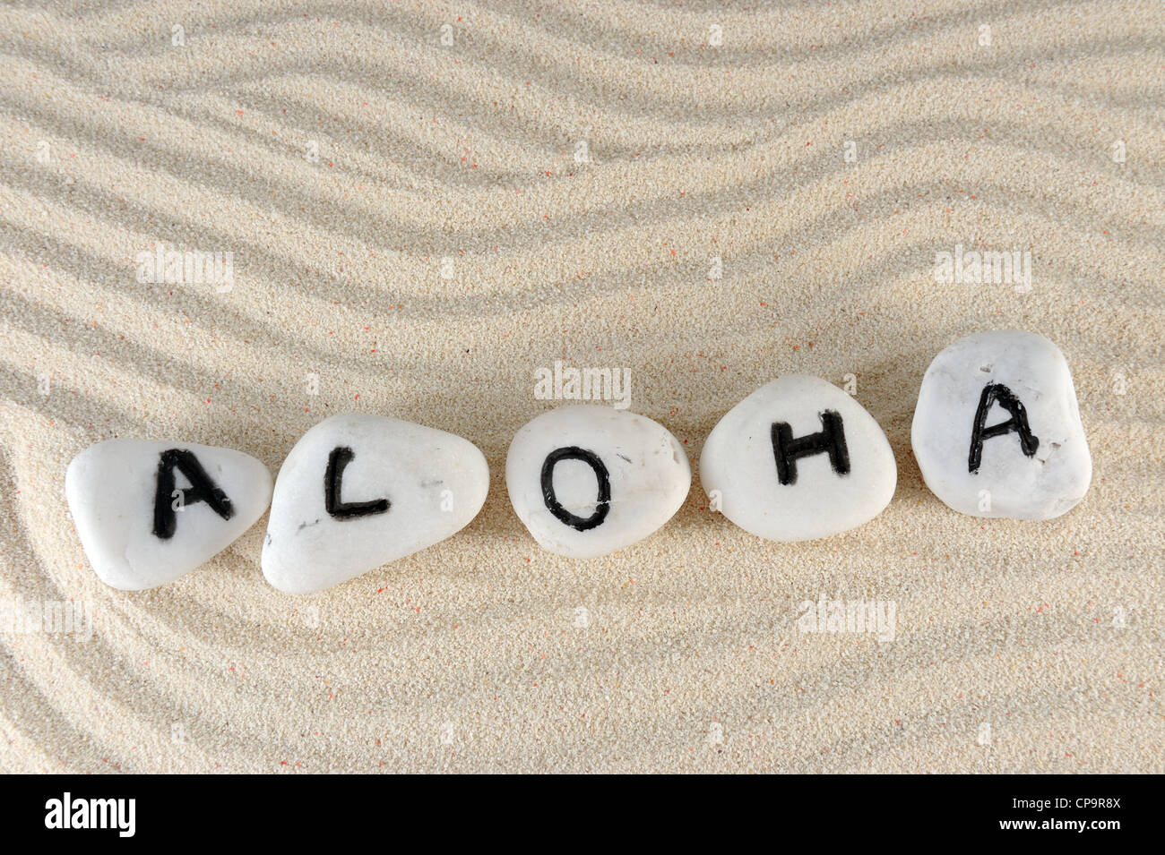 Aloha parola sul gruppo di pietre sulla sabbia Foto Stock