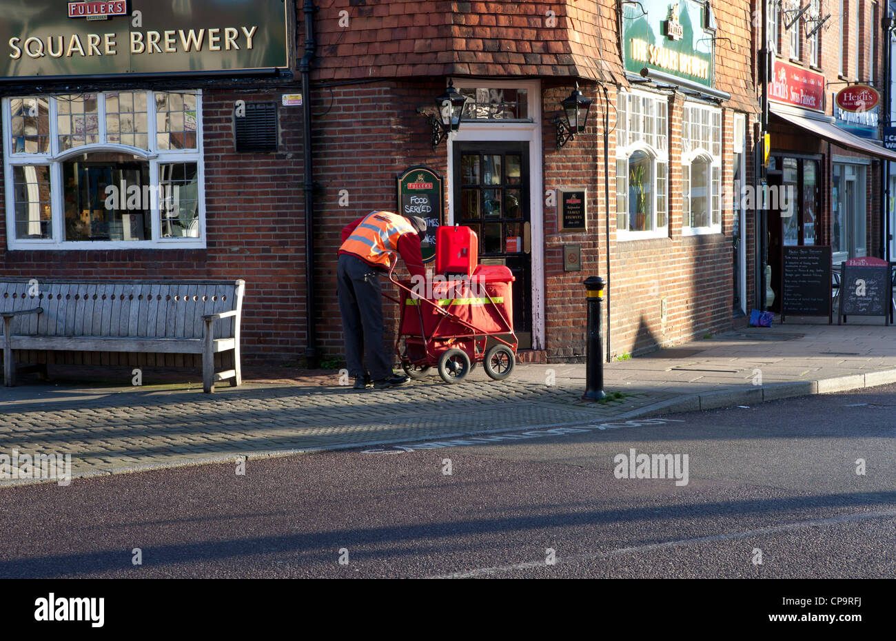 Royal Mail portalettere consegna post da un rosso Post Office trolley in Petersfield, Hampshire, Regno Unito Foto Stock