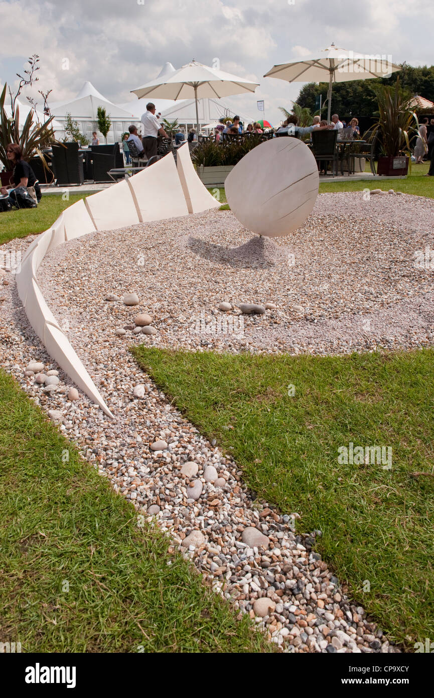 Vista parziale di 'Wave Dance' mostra giardino (scultura & ciottoli bianchi) con persone al Terrace cafe al di là - RHS Flower Show, Tatton Park, Inghilterra, Regno Unito. Foto Stock