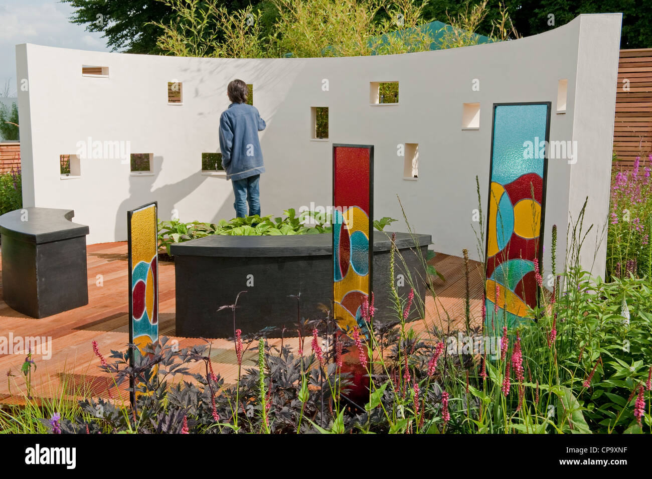 Giovane maschio esamina il muro del suono in bella musica interattiva terapia "giardino un suono Giardino' - RHS Flower Show, Tatton Park, Cheshire, Inghilterra, Regno Unito Foto Stock