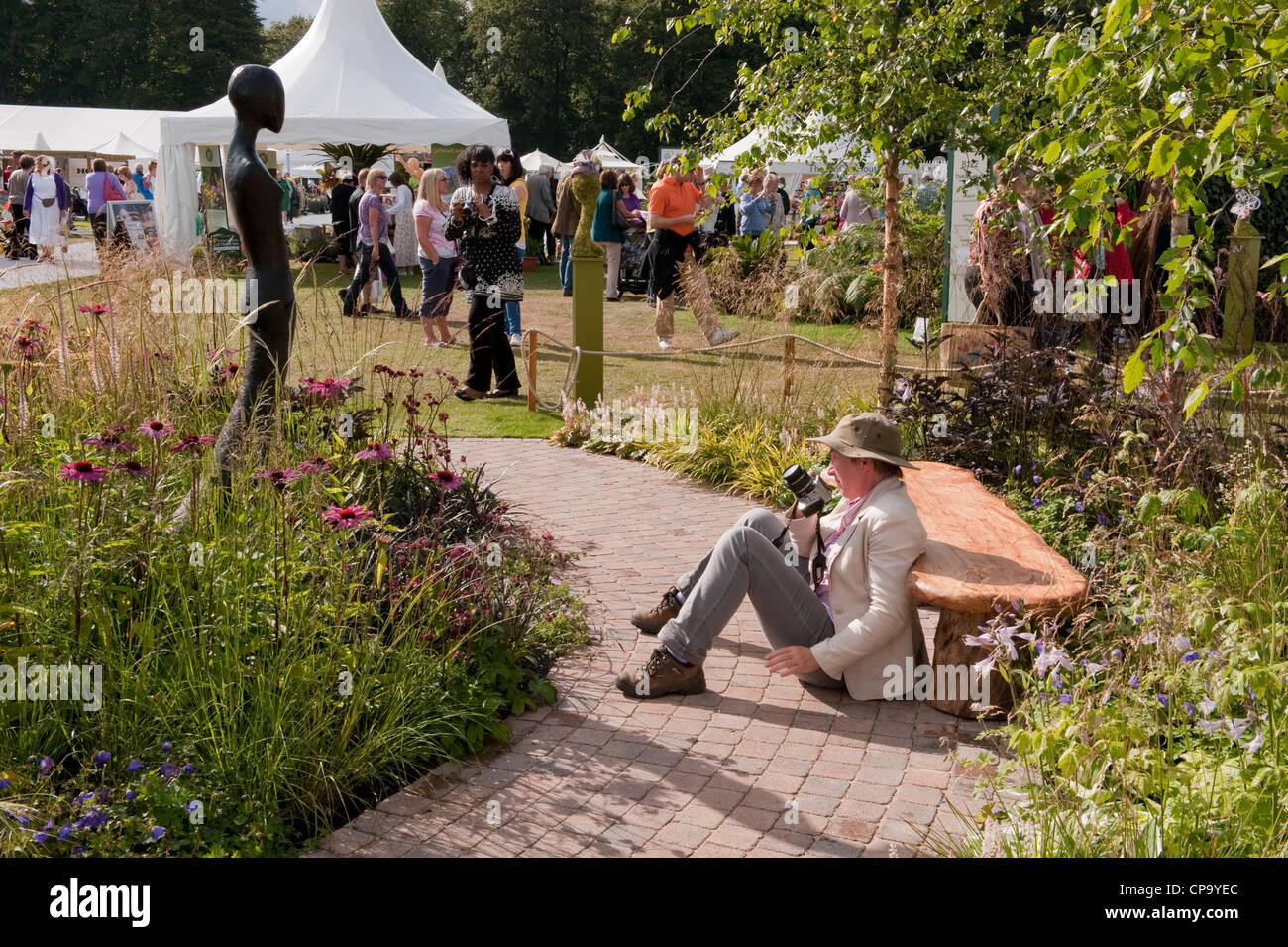 Designer Luisa Rossi Beesley prendendo foto della scultura nella sua "erba con grazia' show garden - occupato RHS Flower Show, Tatton Park, Cheshire England Regno Unito. Foto Stock