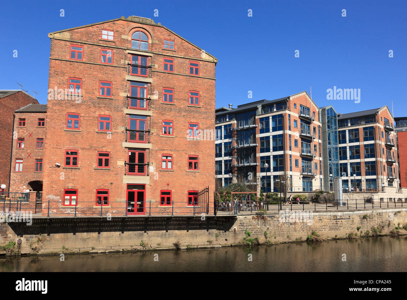 Vecchi edifici industriali e moderni appartamenti sul molo ristrutturato dal fiume Aire in Waterfront District of Leeds England Regno Unito Foto Stock