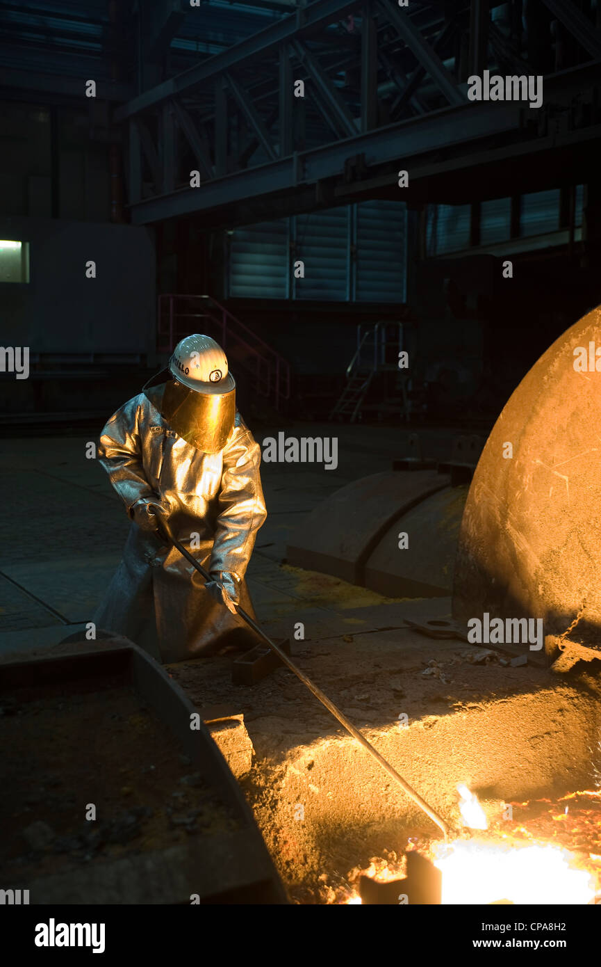 Un lavoratore prendendo un ferro grezzo campione, Duisburg, Germania Foto Stock