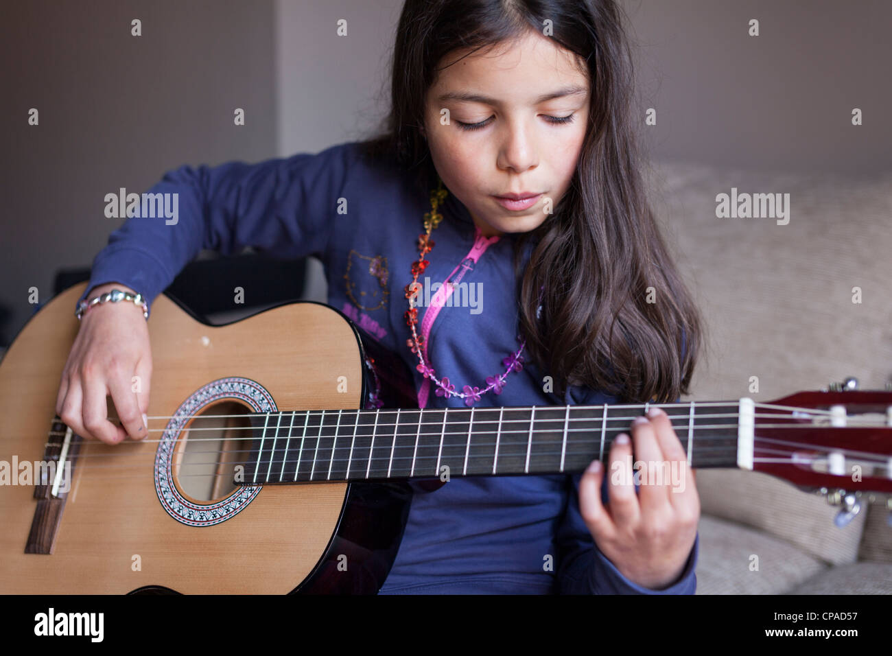 Ragazza,10 anni suona la chitarra acustica Foto Stock