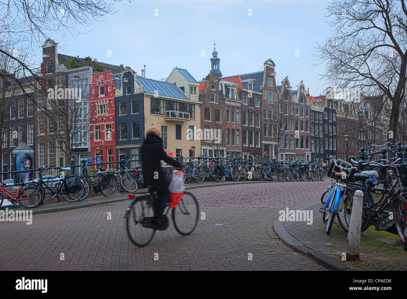 Ciclista attraversando ponte lungo il canale Herengracht canal Foto Stock