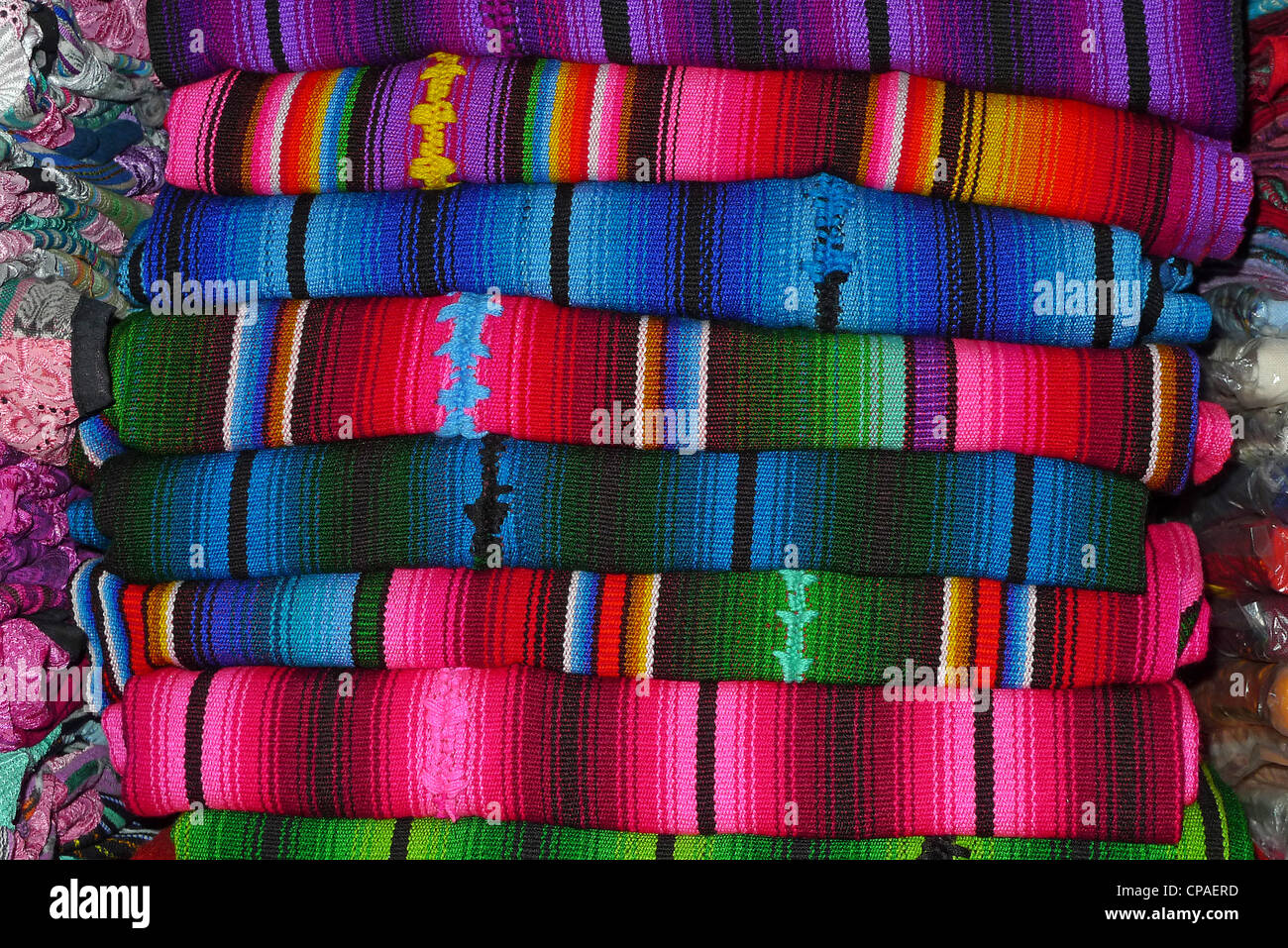 Guatemala una pila di vivaci tessuti di broccato color design tipico per il tradizionale abito in Guatemala Foto Stock