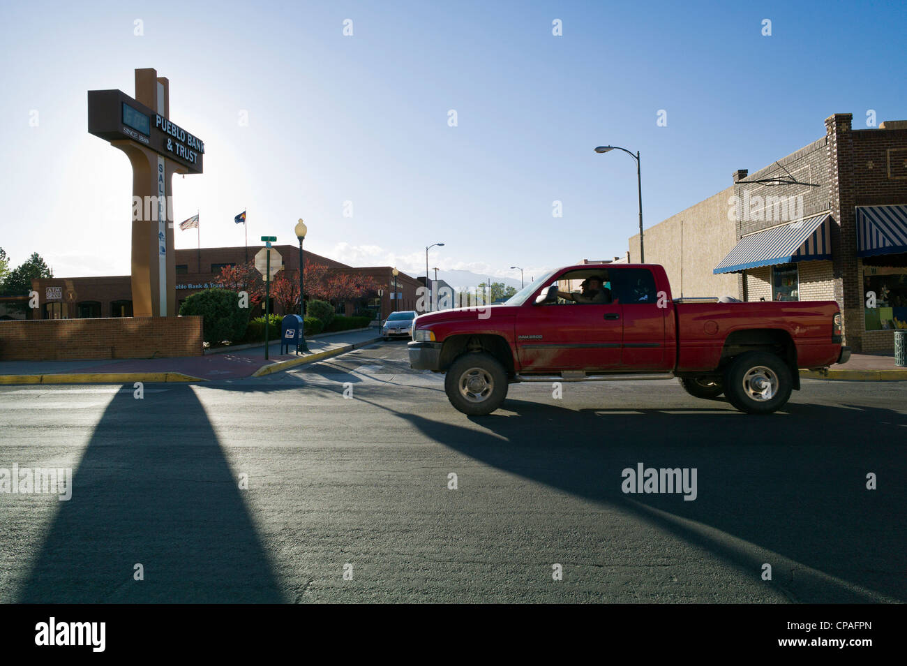 Un pick up truck rigidi mediante il Pueblo Bank & Trust segno che getta una lunga ombra. Centro storico cittadino, Salida, Colorado Foto Stock