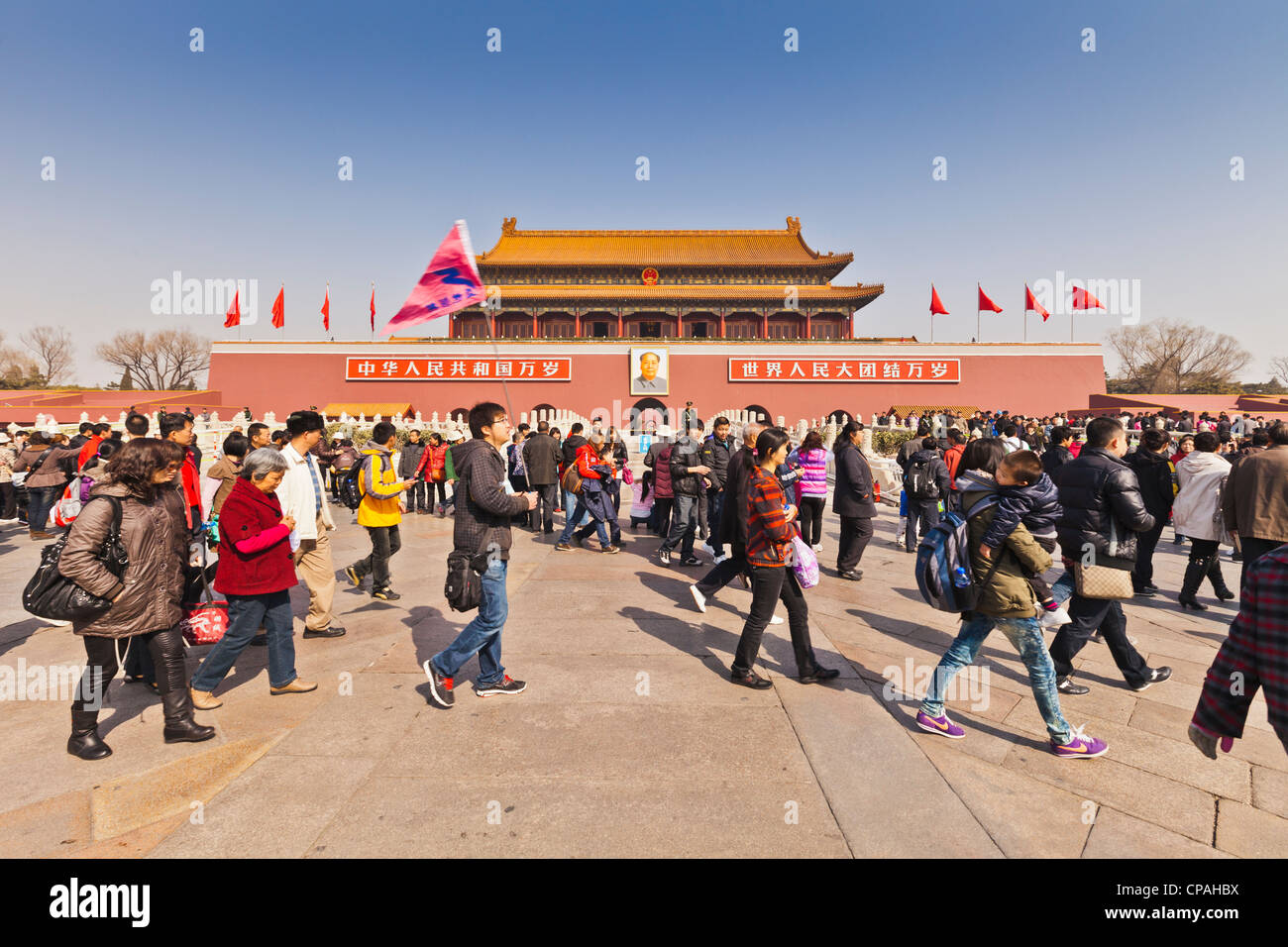 I turisti cinesi e tour a piedi di guida al di fuori del Tian'anmen Gate, la Porta della Pace Celeste, ingresso alla Città Proibita. Foto Stock