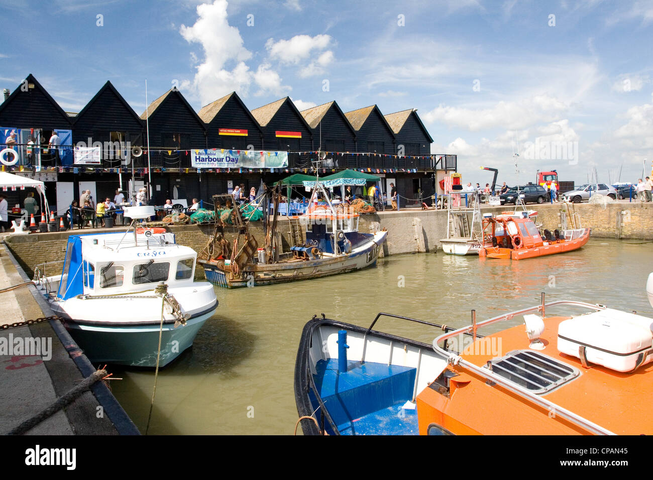 Le barche e i visitatori nel porto di whitstable kent, England, Regno Unito Foto Stock