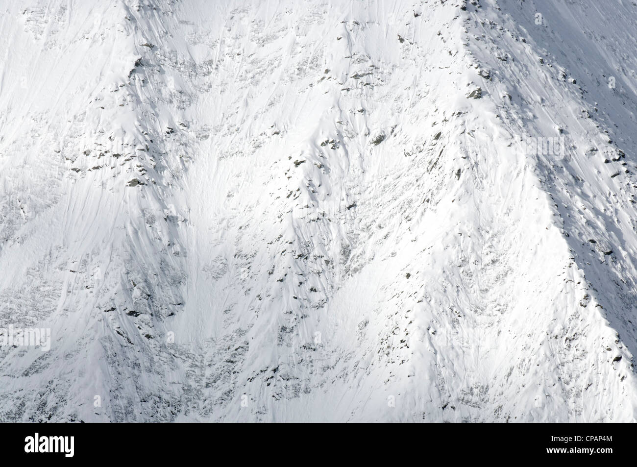 Un raggio di luce che risplende attraverso una montagna alpina Foto Stock