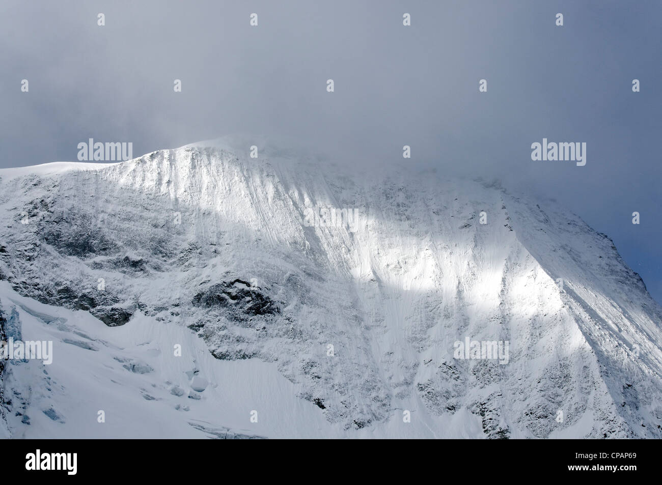 Un raggio di luce che risplende attraverso una montagna alpina Foto Stock