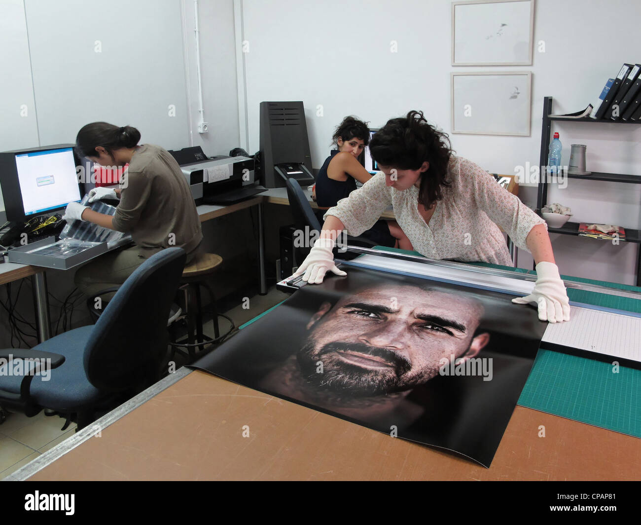 Studente di fotografia la manipolazione di una stampa di grandi dimensioni presso il laboratorio digitale della scuola Naggar per fotografia o Musrara scuola d arte in Gerusalemme ovest Israele Foto Stock