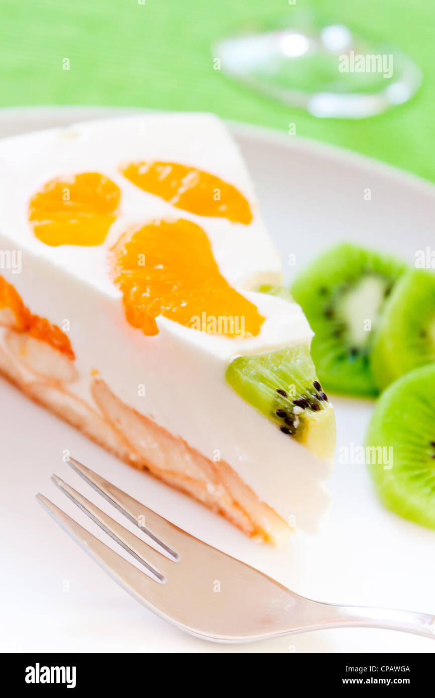Una deliziosa torta con clementina e kiwi su un letto di biscotti Foto Stock