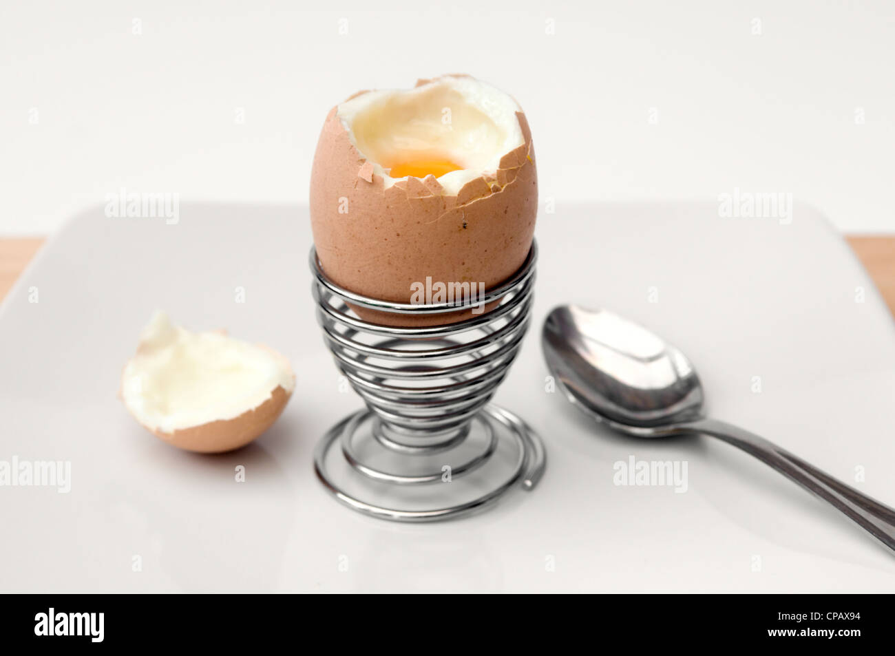 Uova sode con top cut off in metallo coppa uovo su sfondo bianco Foto Stock