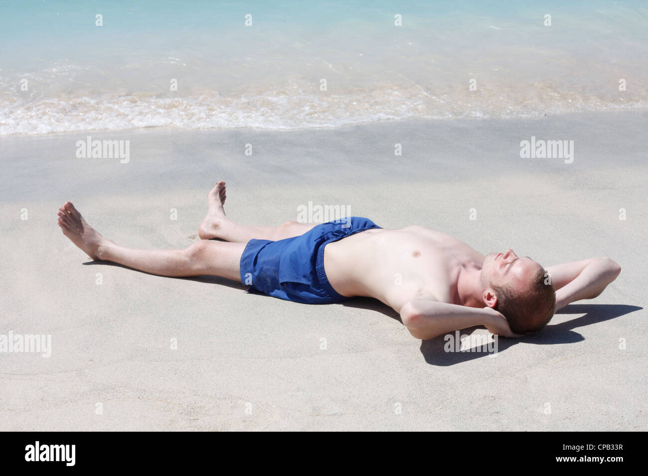 L'uomo rilassante sulla spiaggia Foto Stock